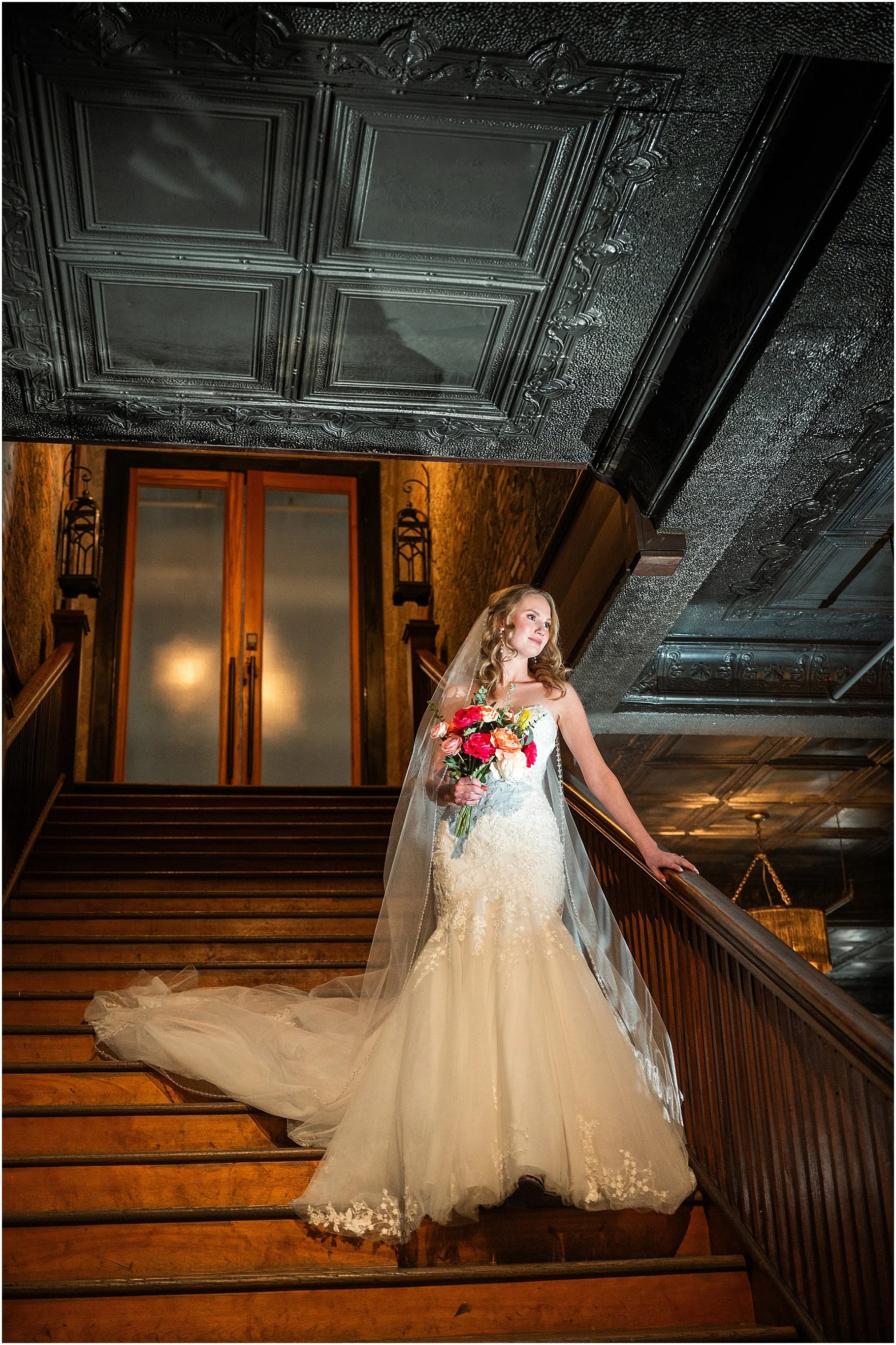 Bride in cathedral veil comes down staircase at Uptown Indigo in downtown Shelby, NC.