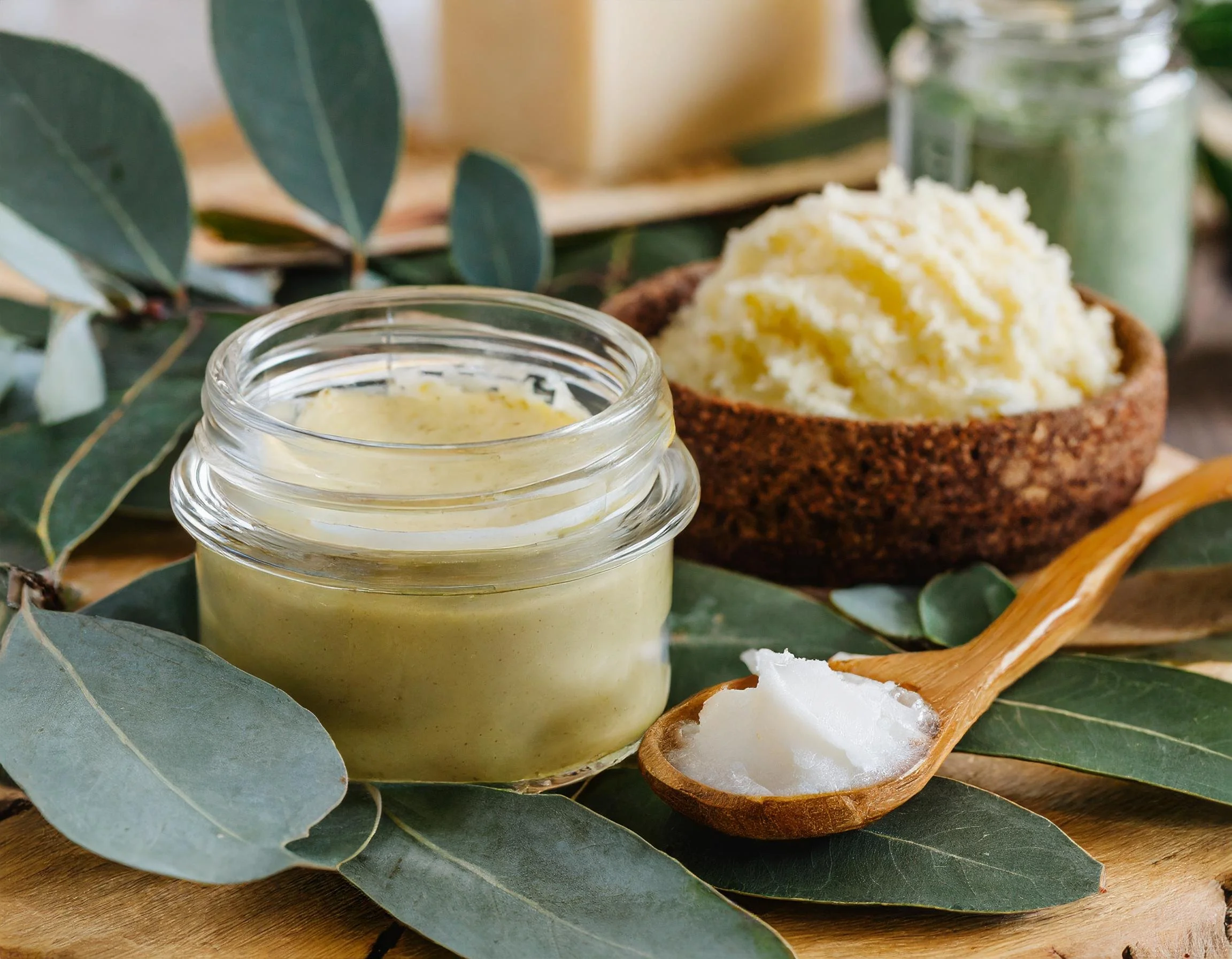 Firefly Homemade white body butter in a glass jar and body scrub on eucalyptus leaves; workshop of m (3).jpg