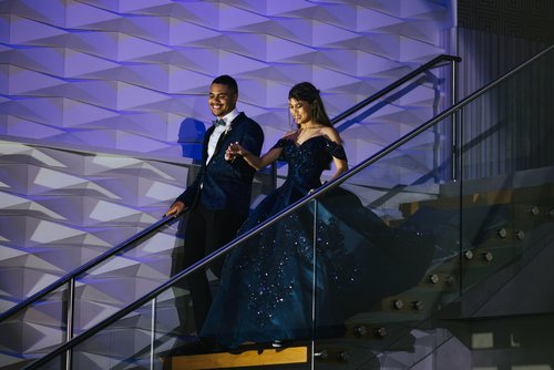 Couple in formal wear walking down stairs at event