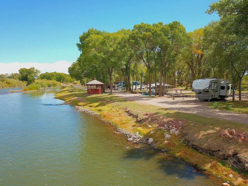 Approved River Front RV sites beside the Rio Grande, with a riverside gazebo and tree-shaded campsites at Woods and River RV Park.