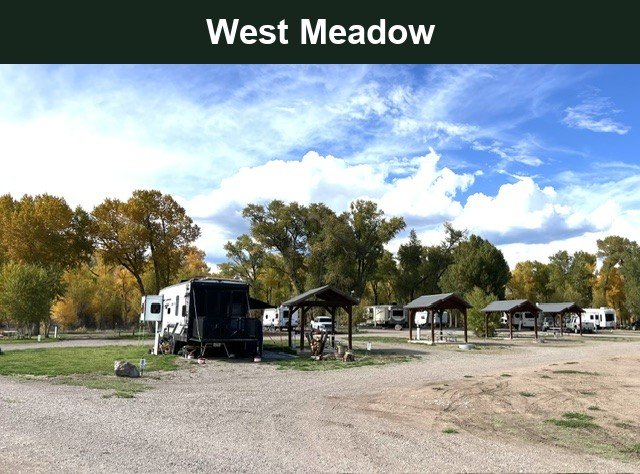 West Meadow RV site area with an RV, covered shelters and autumn trees at Woods and River RV Park.