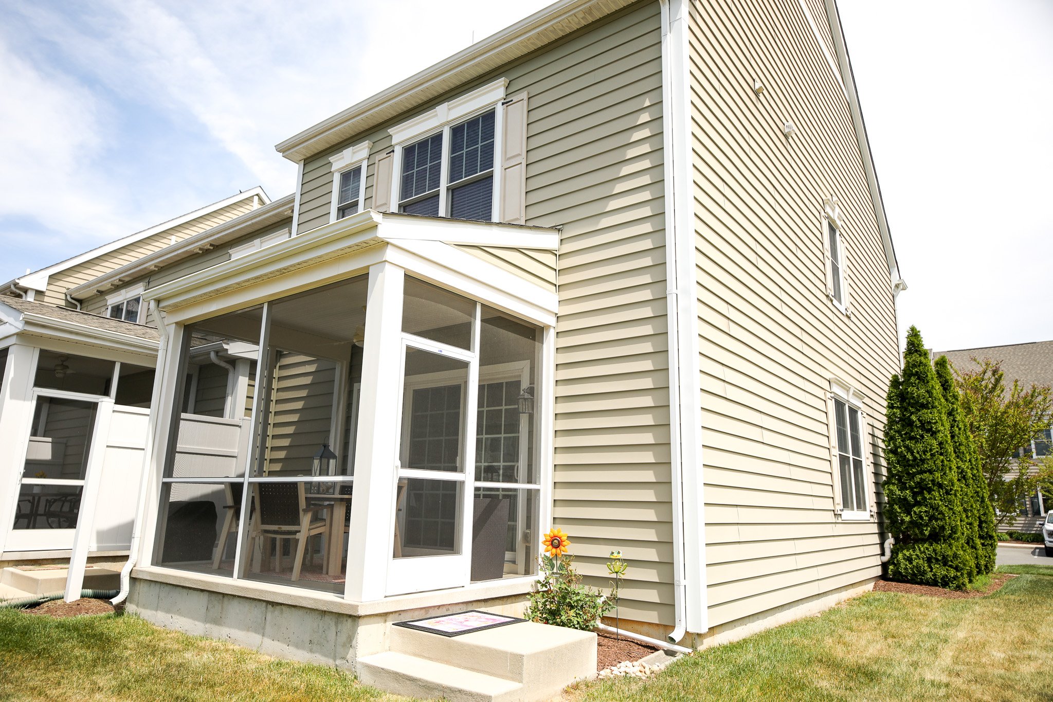 Exterior view of a house with vinyl siding and a screened-in porch.
