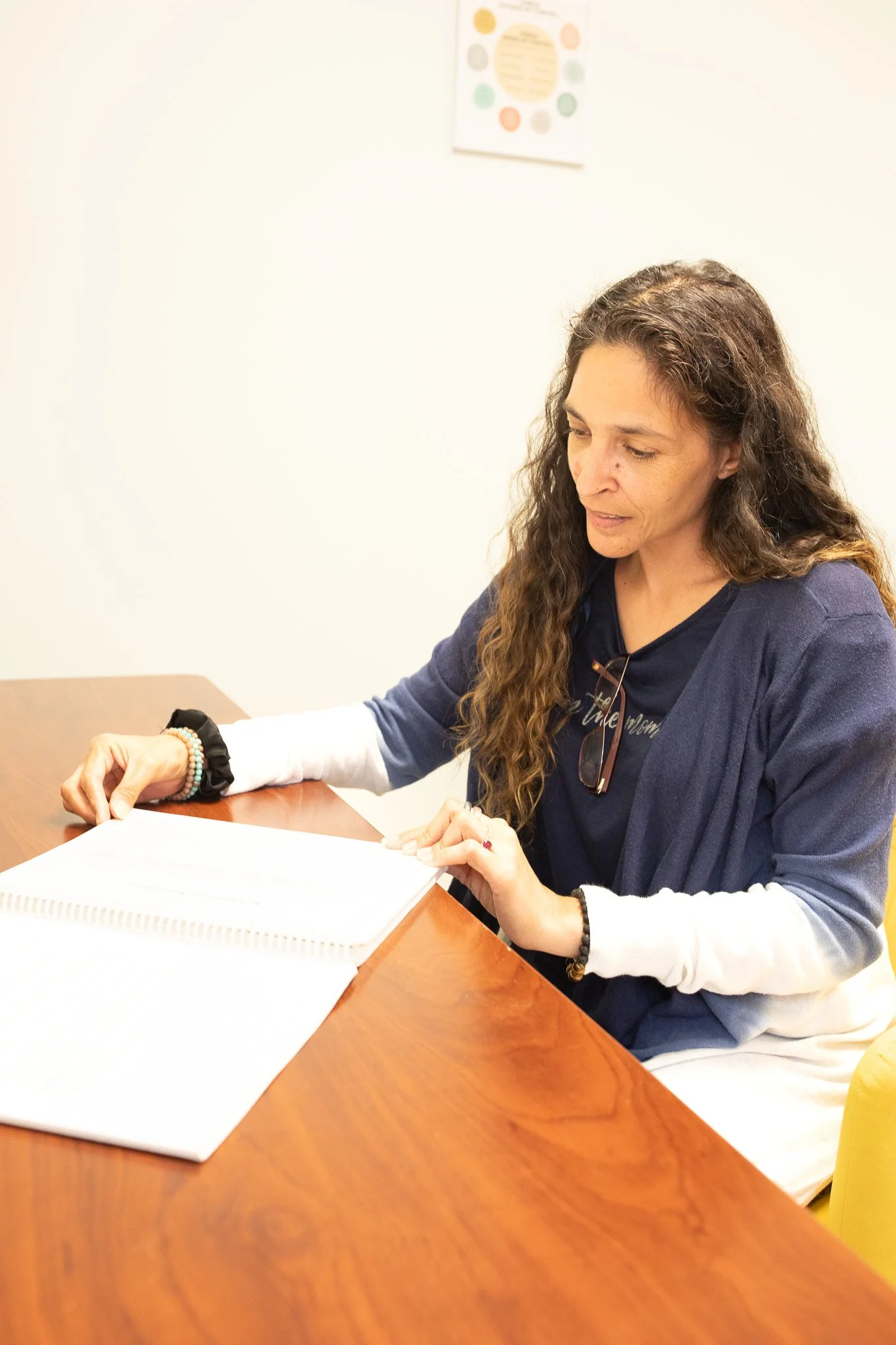 Woman sitting at a wooden table reading a document