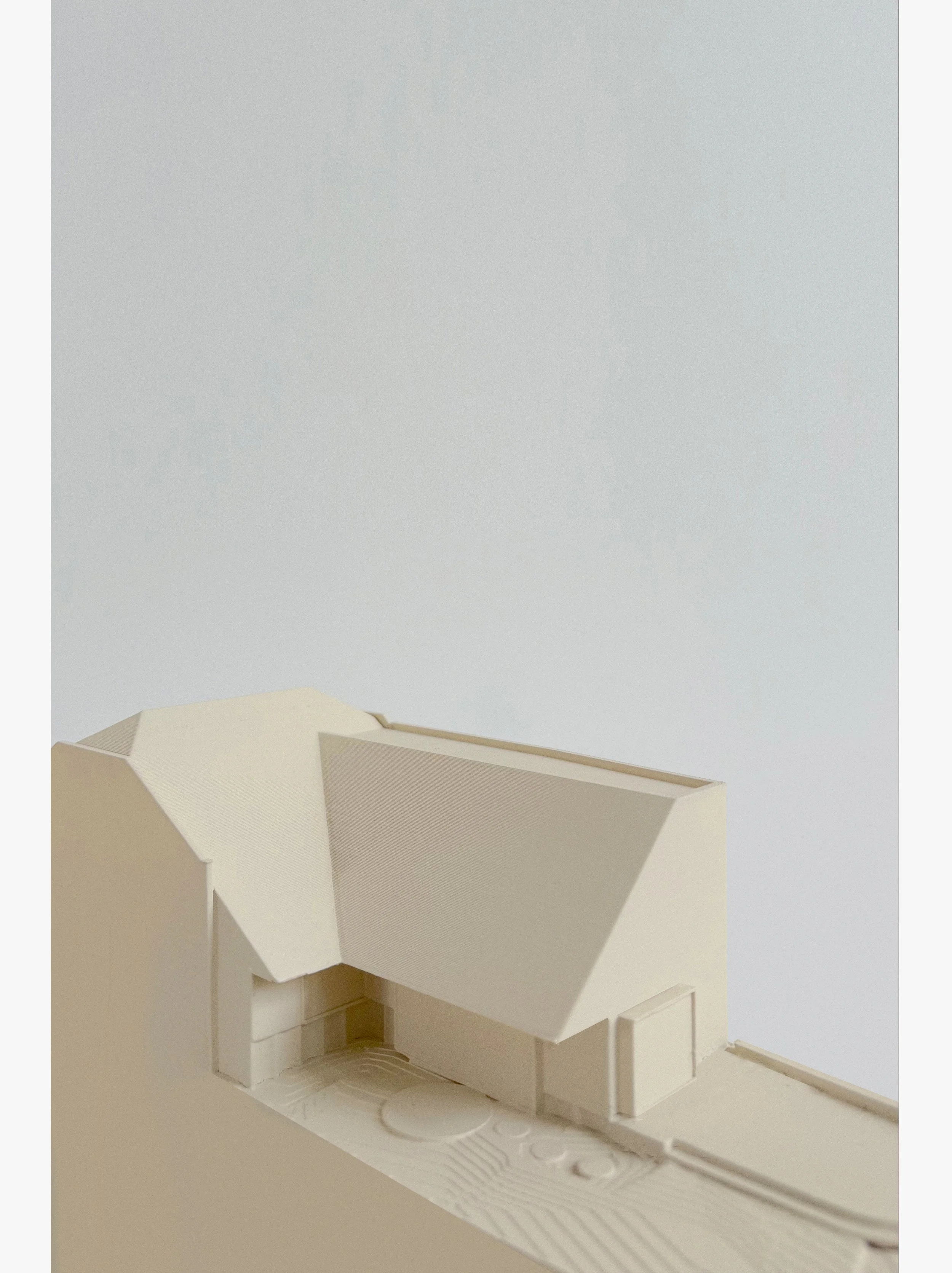 Architectural model of a modern house with geometric design on a white background.