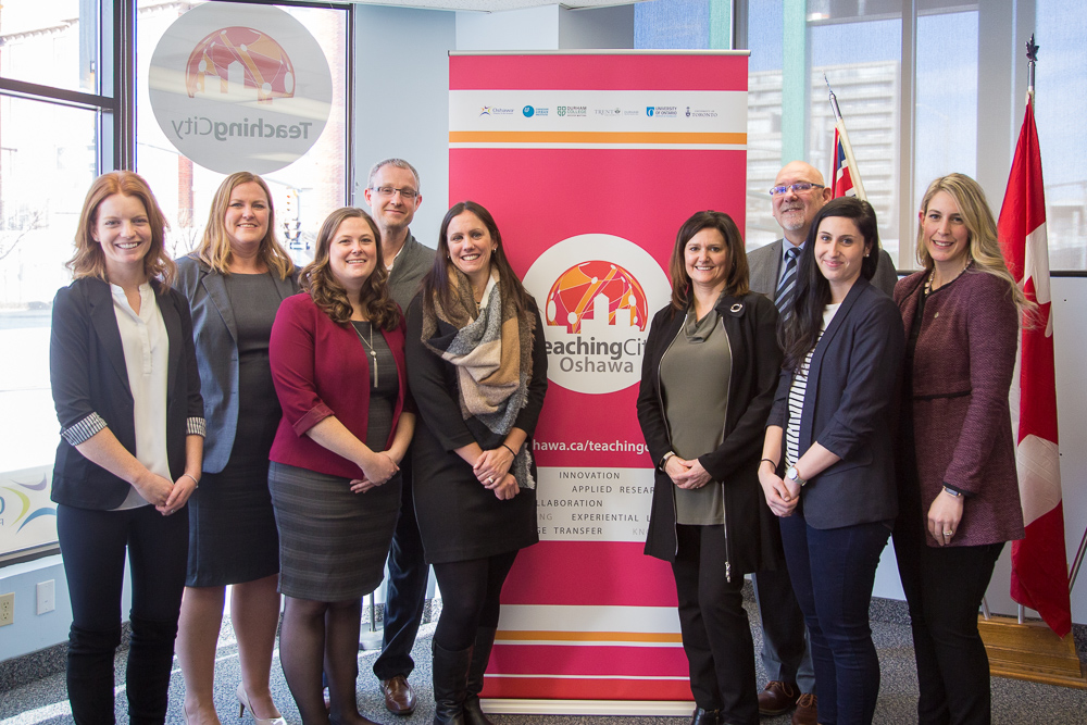 City Idea Lab steering committee standing in front of a banner