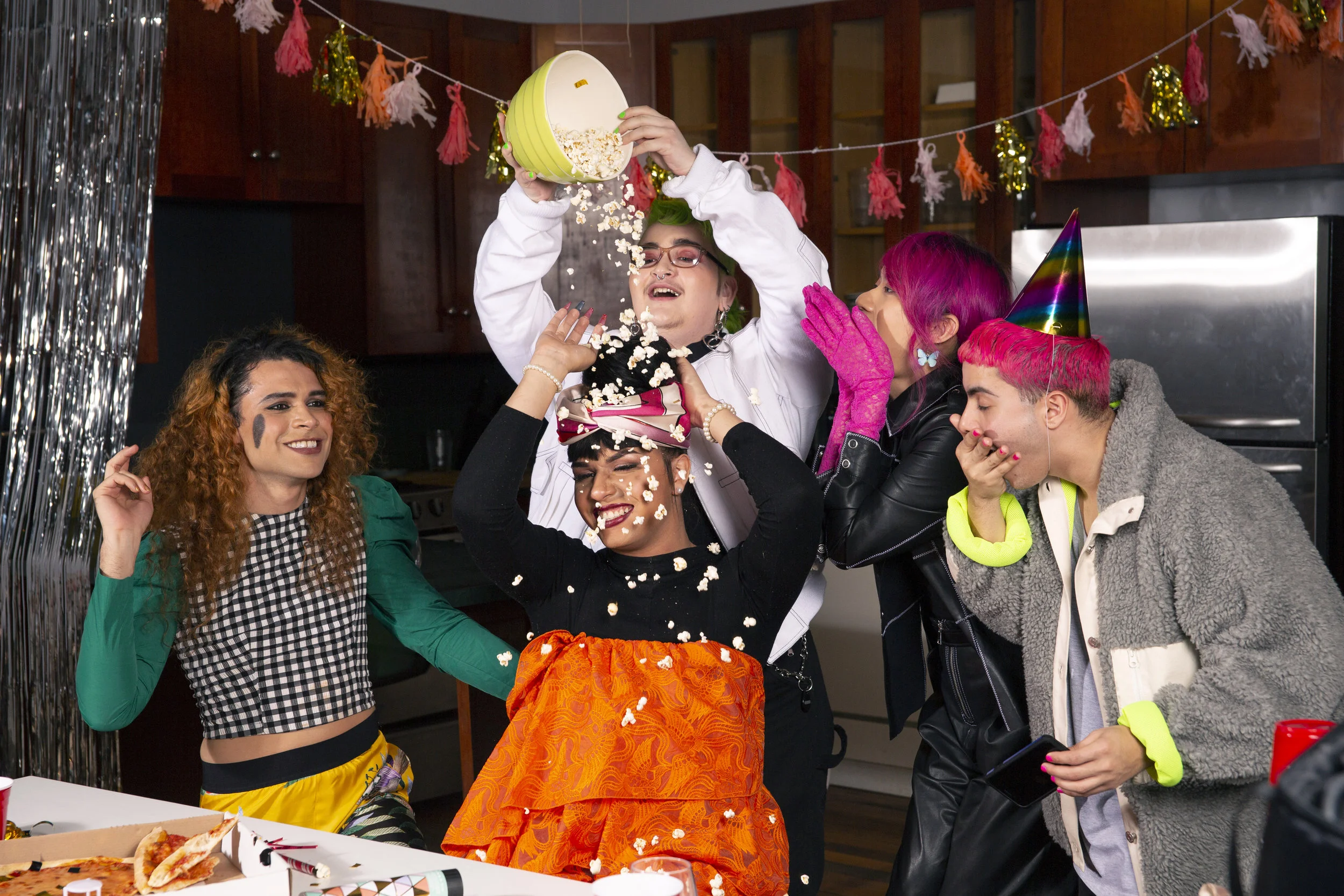 Image Description: A group of friends of varying genders playing with popcorn at a party Photo Credit: The Gender Spectrum Collection