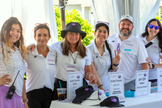 Five women and one man pose at a charity golf tournament.