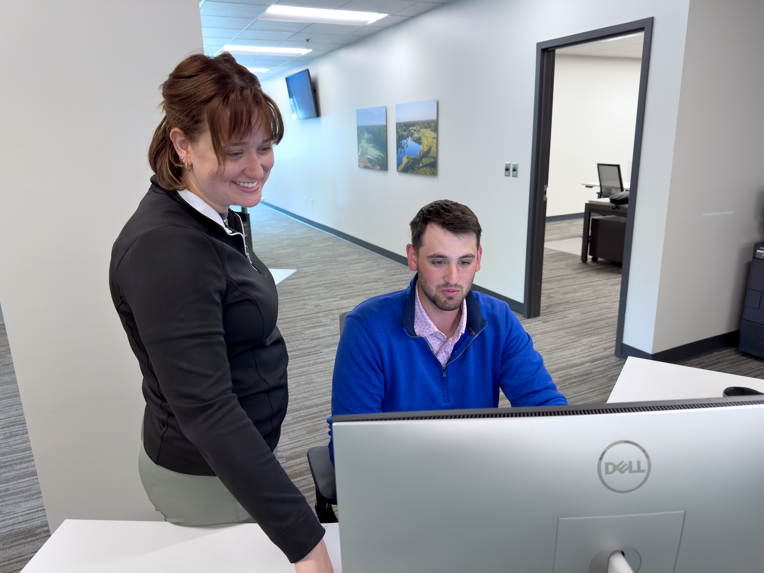Two software support team members look at a computer.