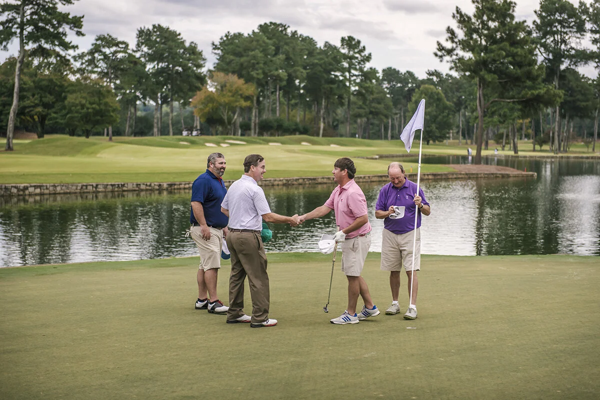 Golfers shake hands at the conclusion of an association golf event.