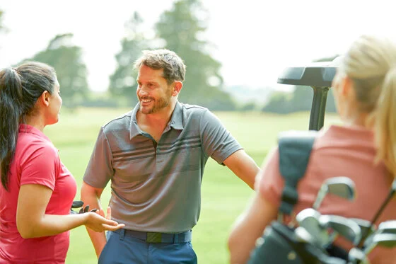 A male and female golfer chat at a charity golf event.
