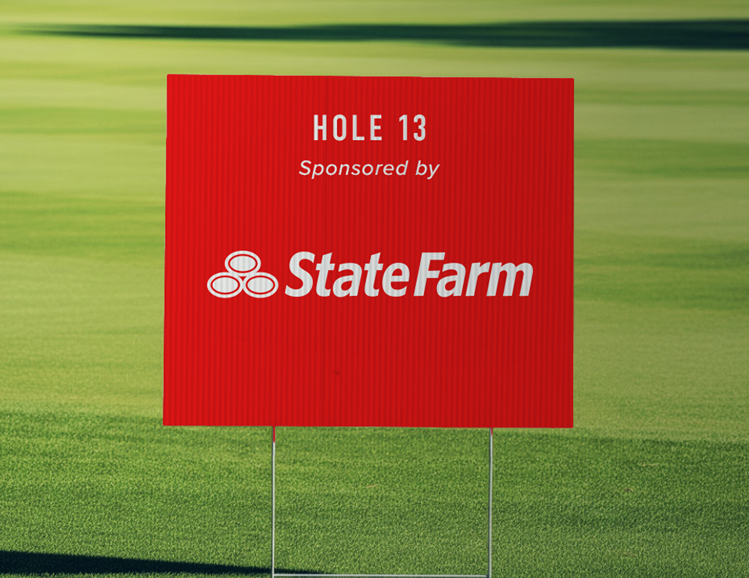 A golf hole sponsor sign on a tee box at a charity golf event.
