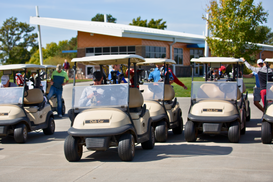 Golfers sit in golf carts before the start of a charity golf tournament.
