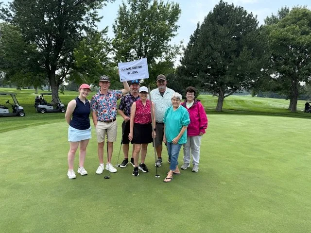 Golfers pose with a pin flag at the Nebraska High School Officials Association golf tournament.