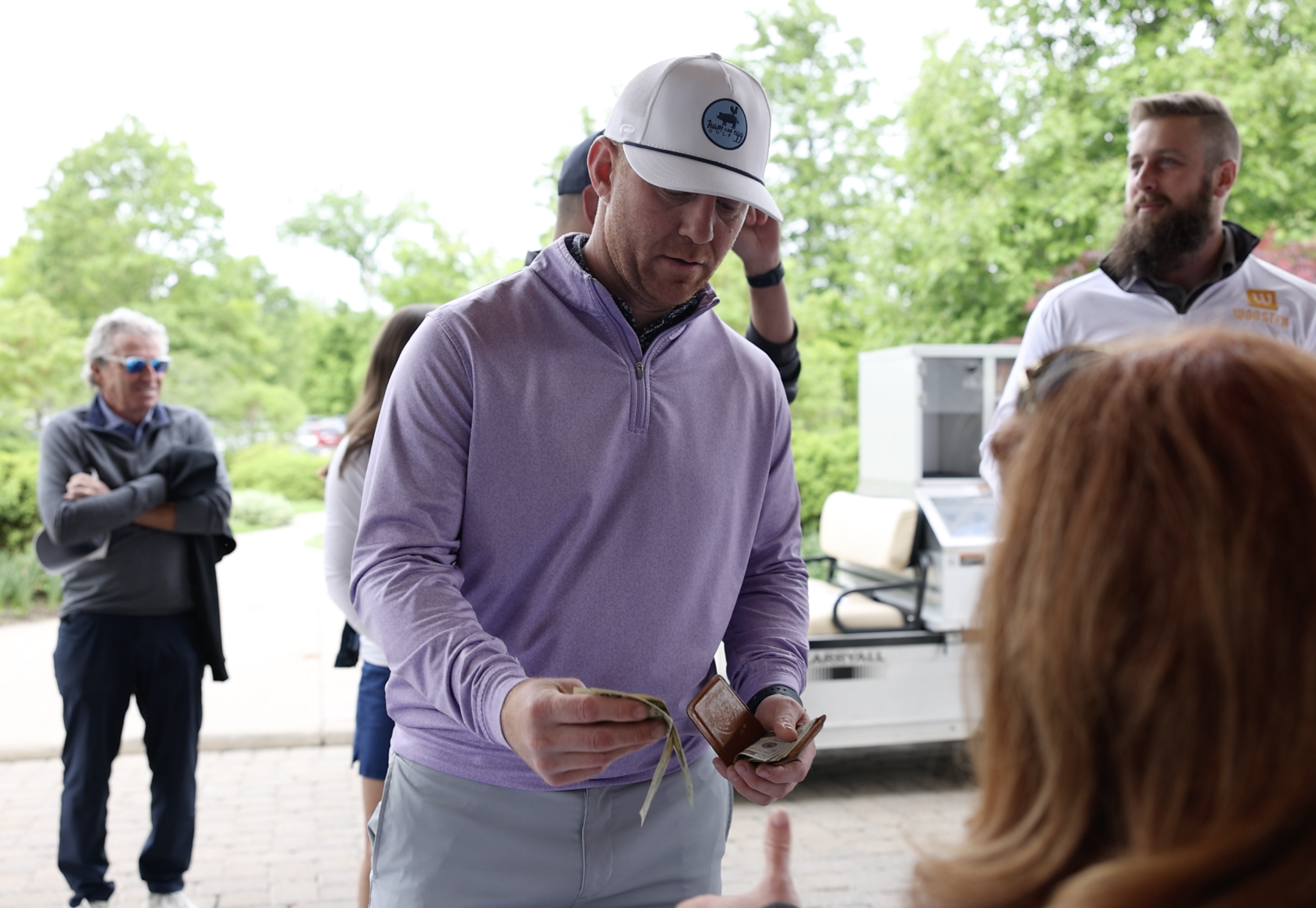 A golfer makes a donation during a charity golf tournament.