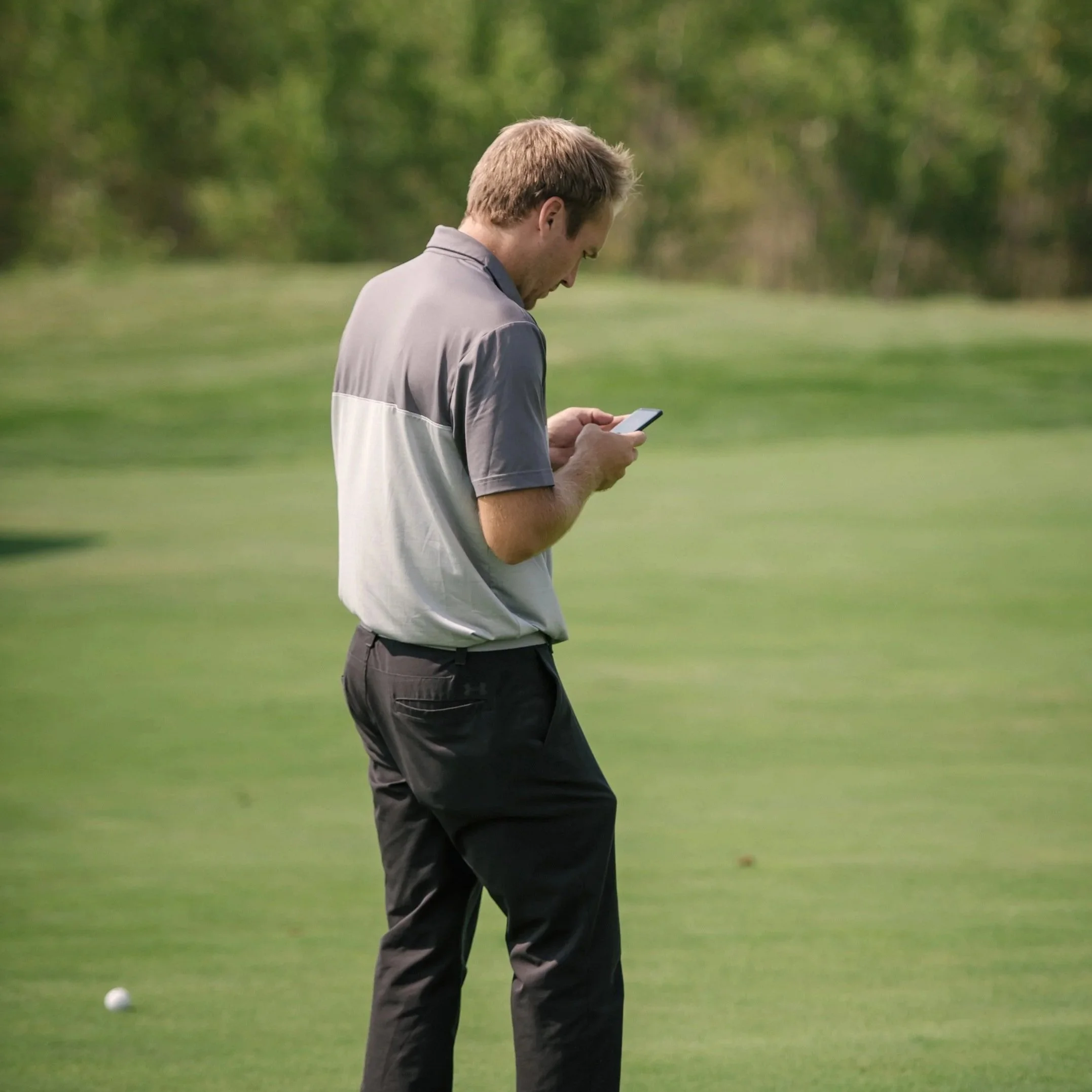 A golfer uses his mobile phone to purchase mulligans at a charity golf tournament.