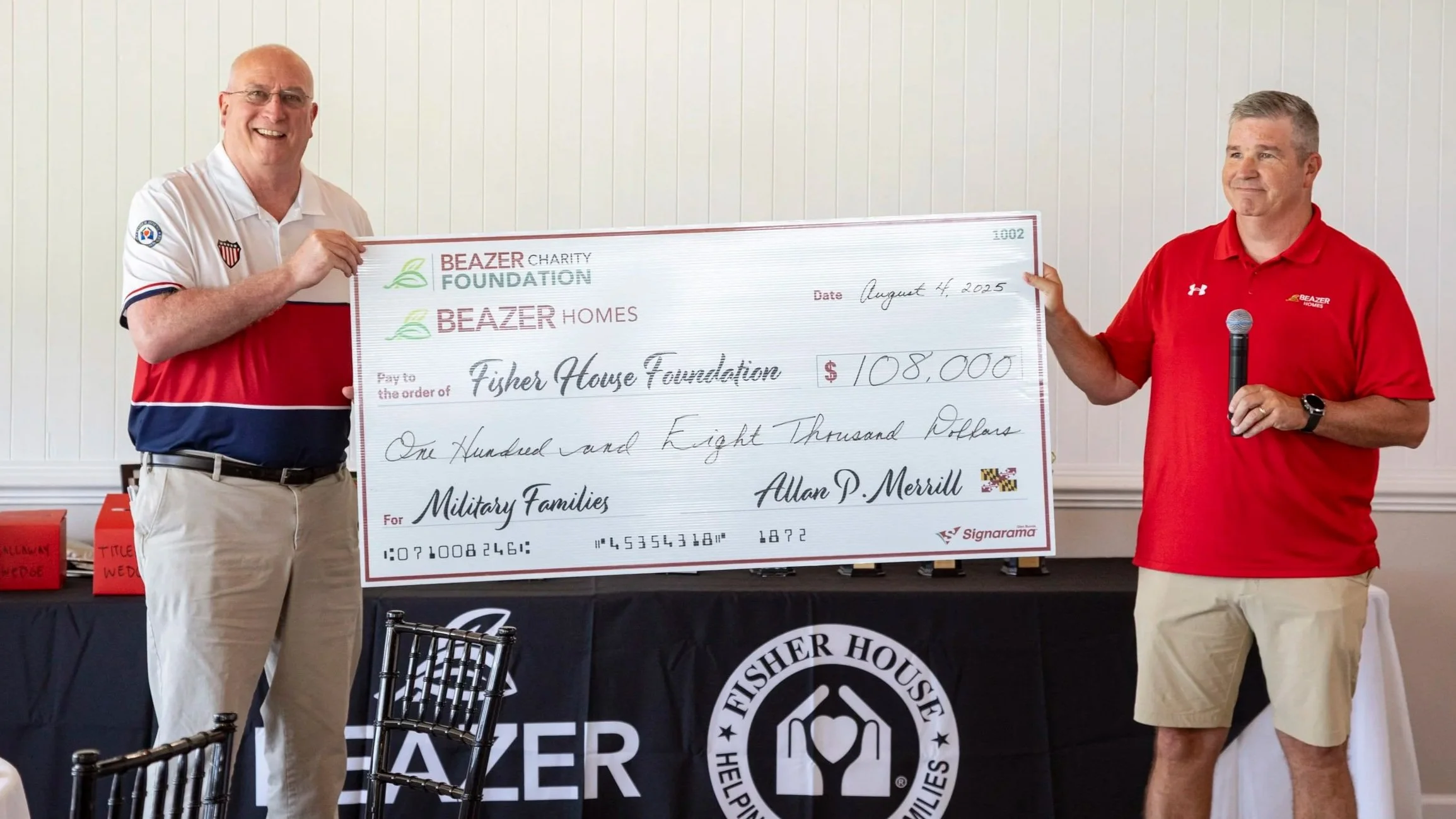 Two men pose with a big check showing the proceeds of the charity golf tournament to be donated to Fisher House.
