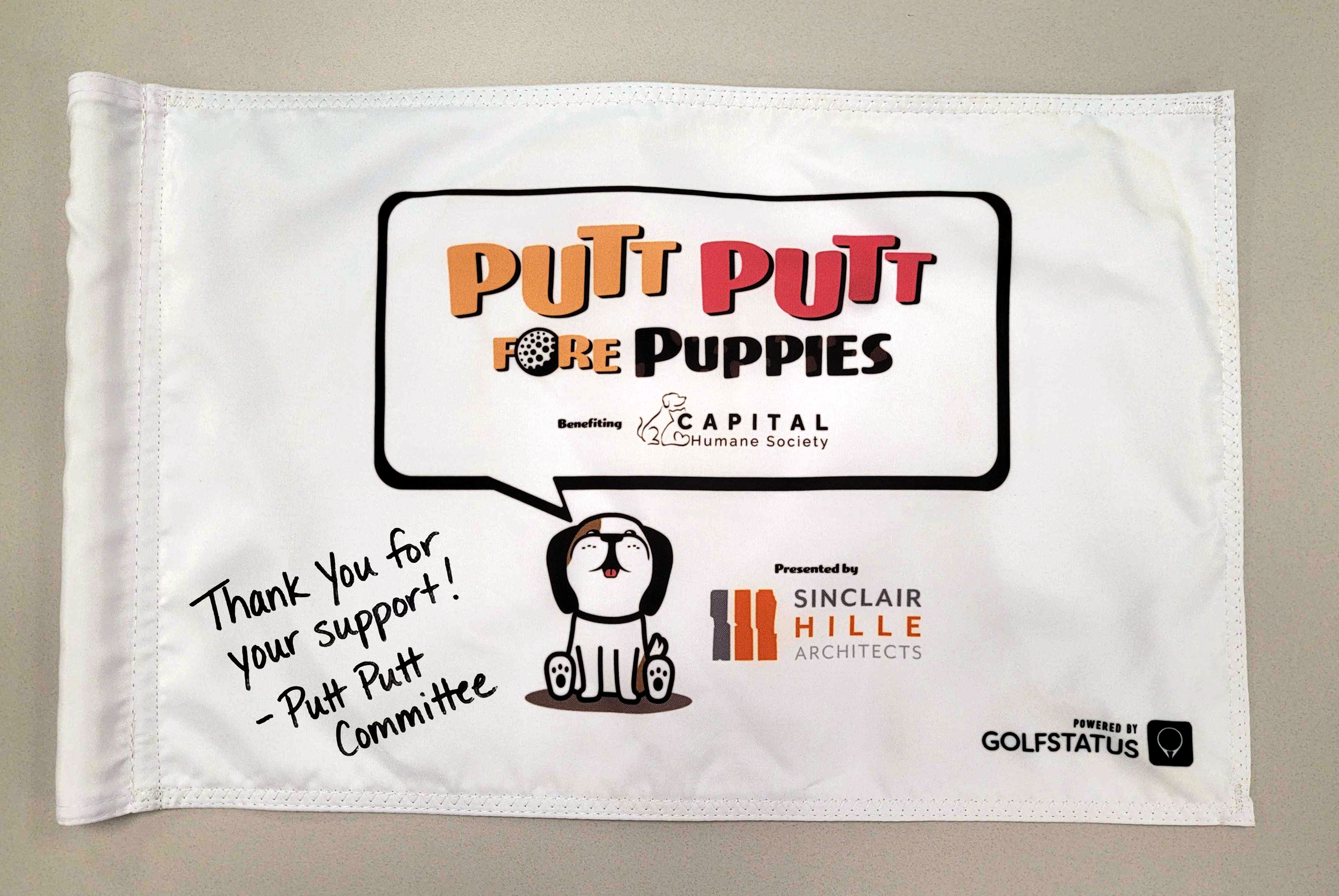 A custom pin flag that's been signed as a thank you for a golf tournament sponsor.