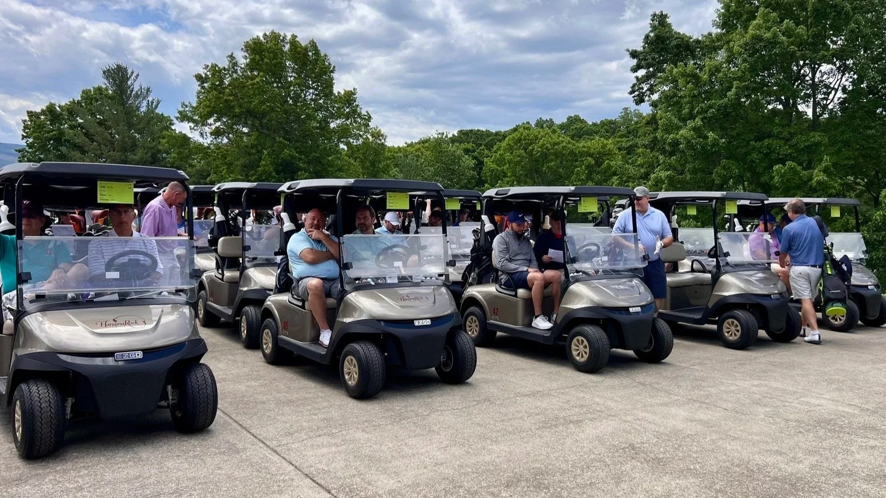 Golf carts line up at the start of a sold out charity golf tournament.
