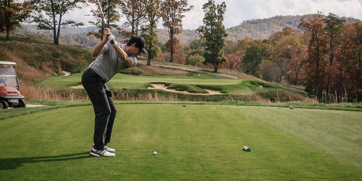 A golfer prepares to hit a tee shot at a golf tournament. Mulligans are commonly used on tee shots.