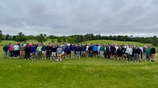 Participants in the First Responders Golf Outing pose on the green at the golf course.