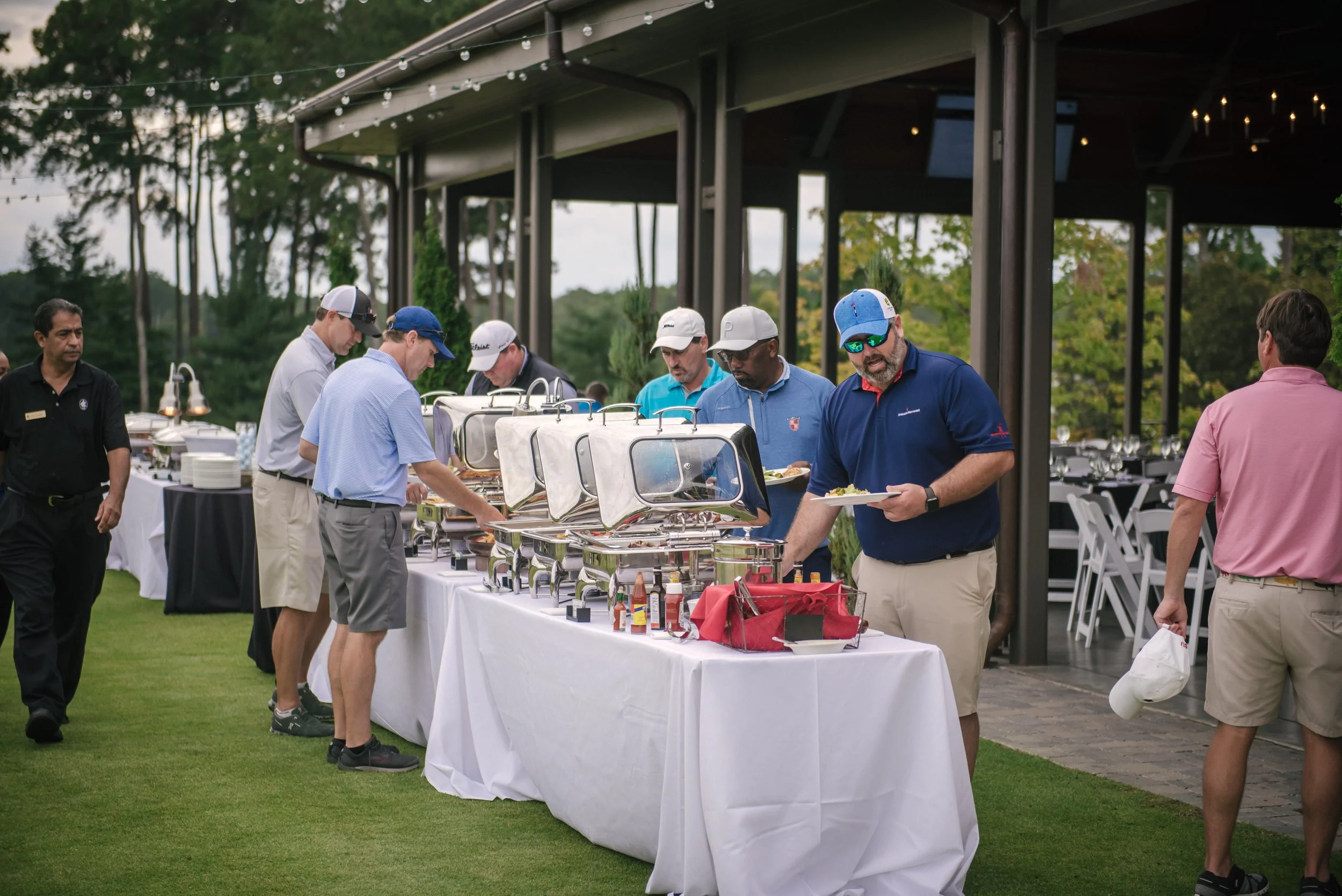 Golfers get their food from a buffet at a post-golf tournament banquet.