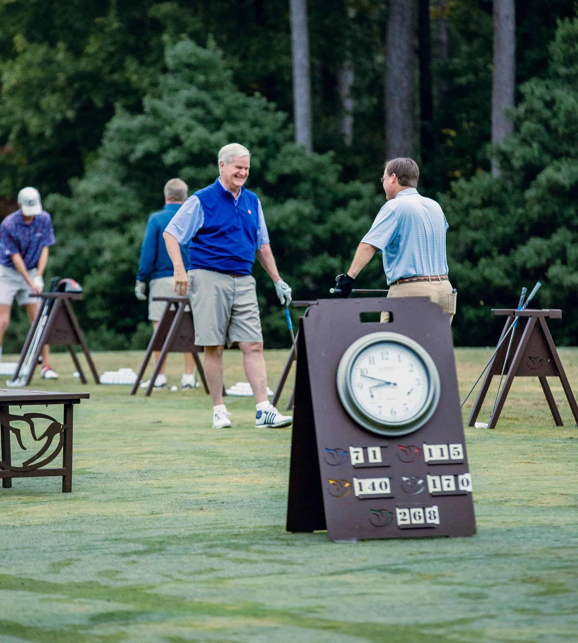 Two golfers chat on the driving range at a charity golf tournament organized by a chaptered nonprofit.