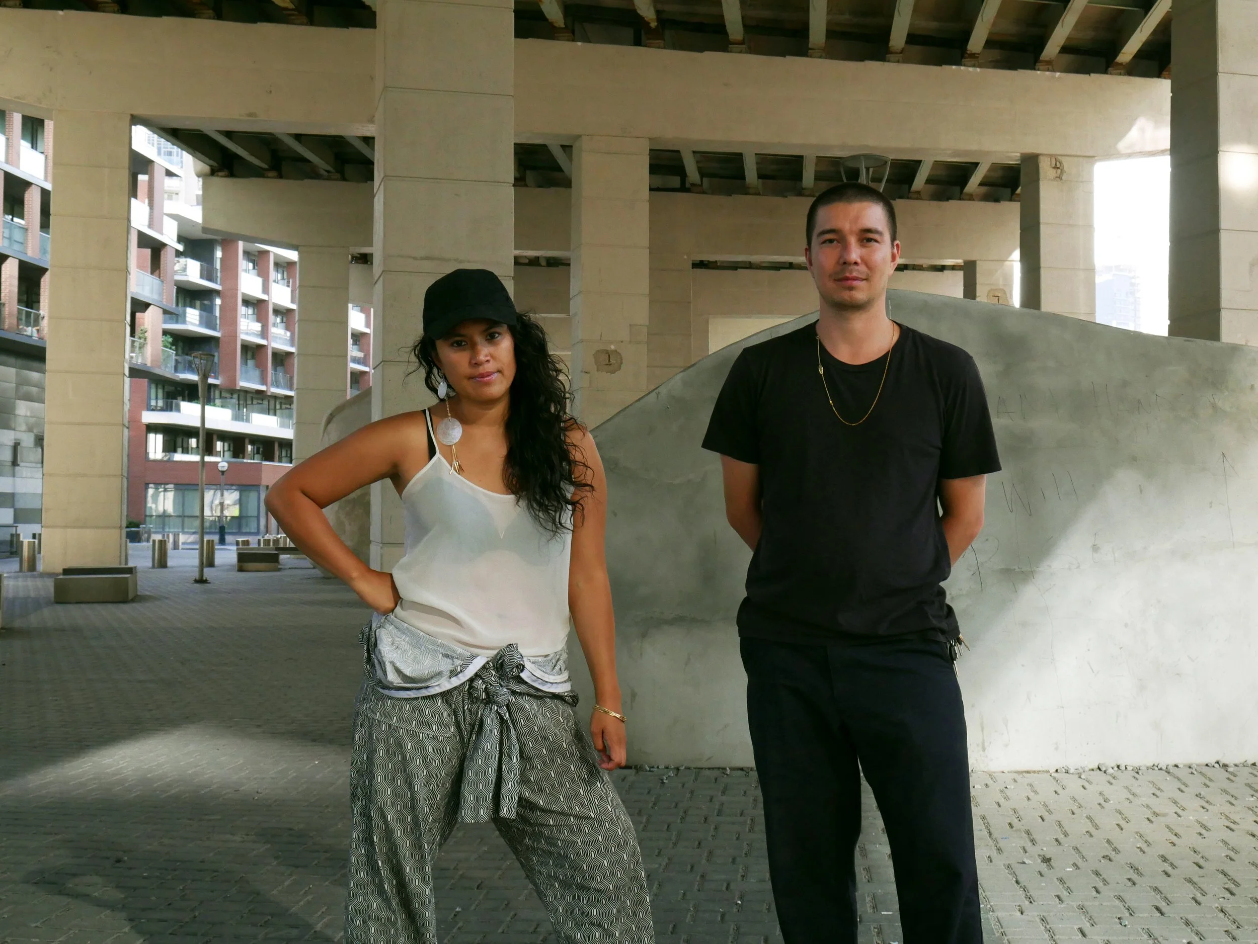 Electronic duo Phèdre standing under a concrete bridge.