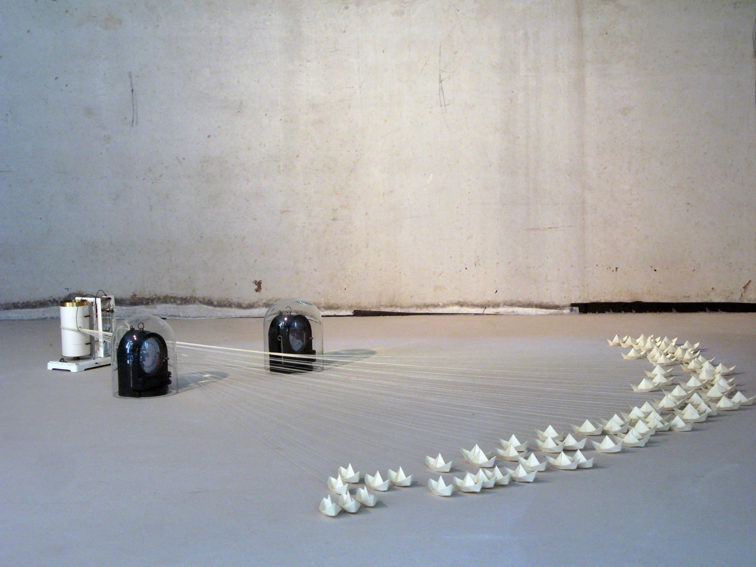 Between Sea and Sky, Vintage weather recording devices, glass domes, string, altered photos, and paper boats. (In this kinetic sculpture, the boats are gradually pulled towards the narrow passage between the glass domes where they pile up in a slow motion collision that takes 6 weeks to occur.) 2014.