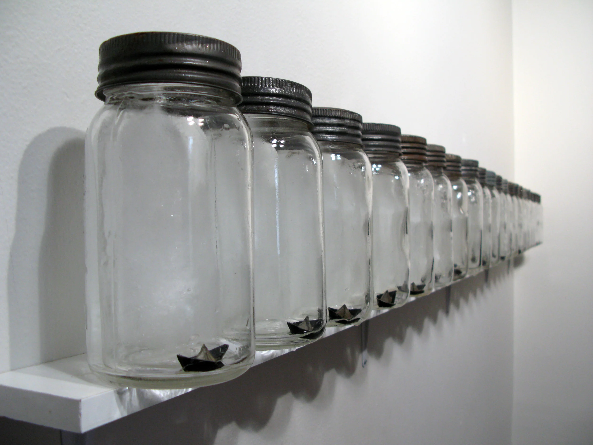 Precarious (21 Ice Warnings), 2012. (As the ice melts, the centre of gravity shifts causing the precariously placed jars to fall off the shelf to the floor.)