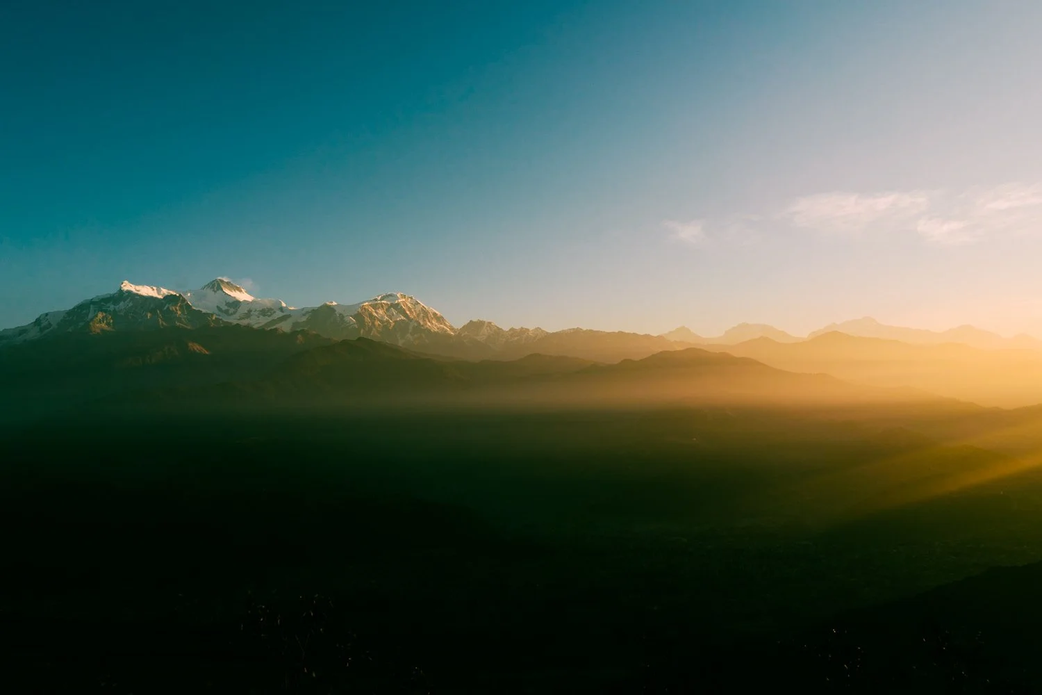 Golden sun rays breaking over a mountain valley landscape, edited with the Sun-Drenched Valley C1 adventure Lightroom preset.