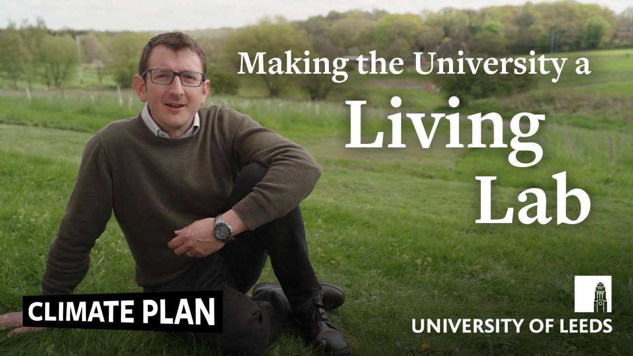 A man sitting on grass in a park with trees and hills in the background. Overlaid text reads 'Making the University a Living Lab'. Additional text includes 'Climate Plan' and 'University of Leeds', with a logo of a tower.