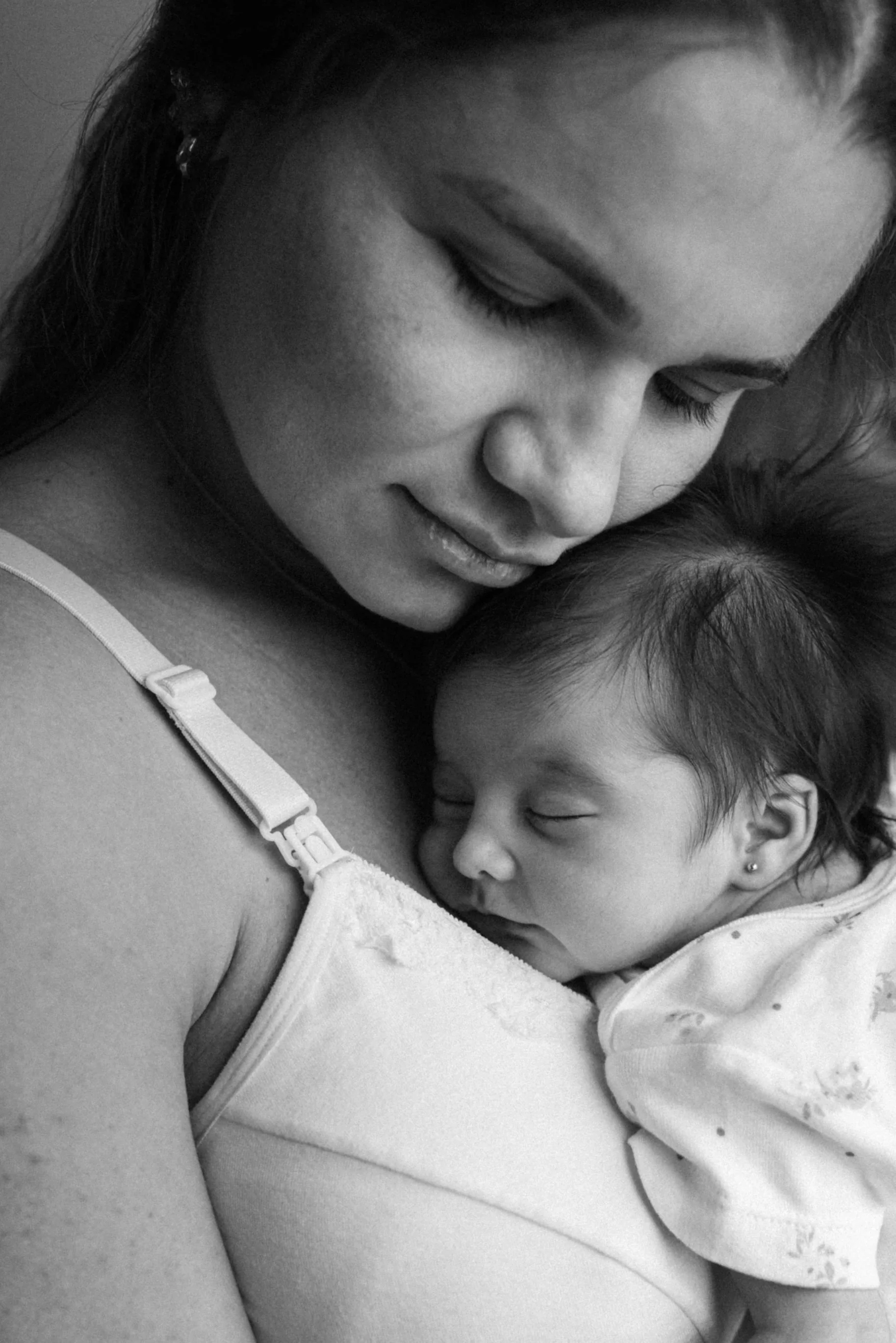 a black and white photo of a mother holding her newborn.