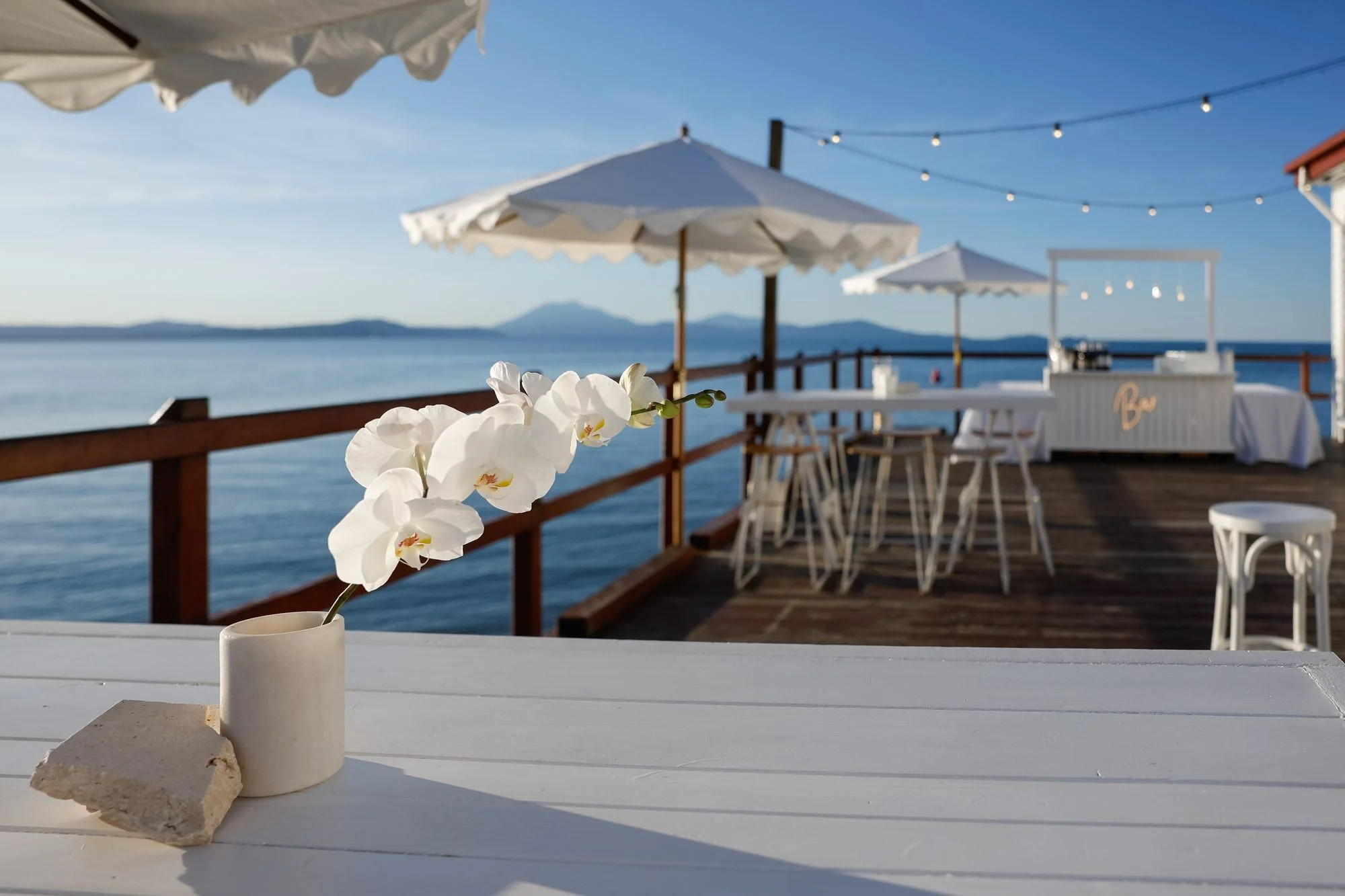 waterfront-deck-white-umbrellas-orchid-decor.jpg