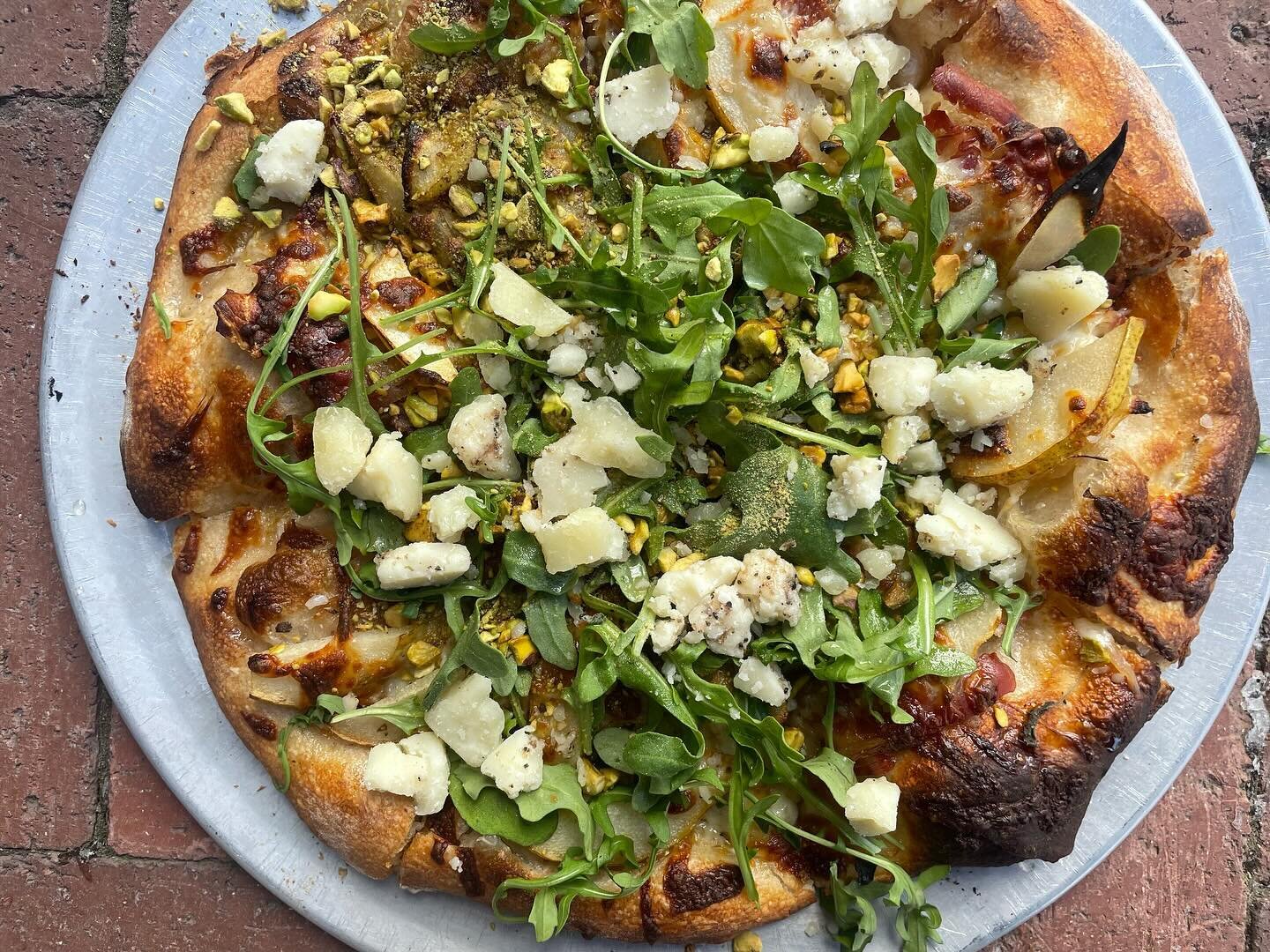 The Perfect Pear with EVOO, pears, prosciutto, caramelized onions, mozzarella, arugula, toasted pistachios, truffles moliterno cheese, white balsamic reduction.