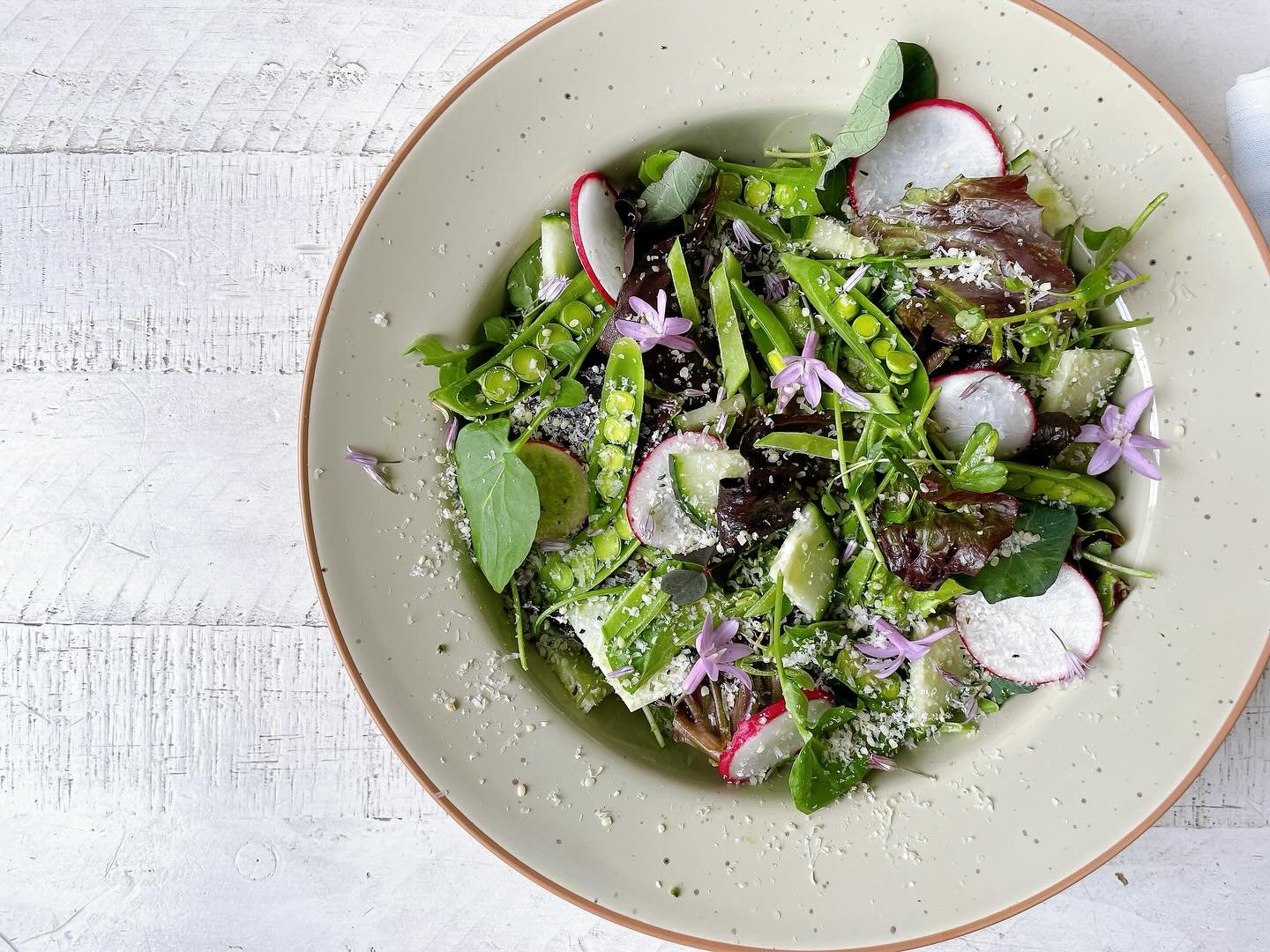 We’re still hanging on to spring around here!
.
Crisp salad with spring herbs and greens, gem lettuces, sugar snap peas, snow peas, French breakfast radish, English cucumbers, chive blossoms, spring flowers, with Parmesan and hemp seeds tossed