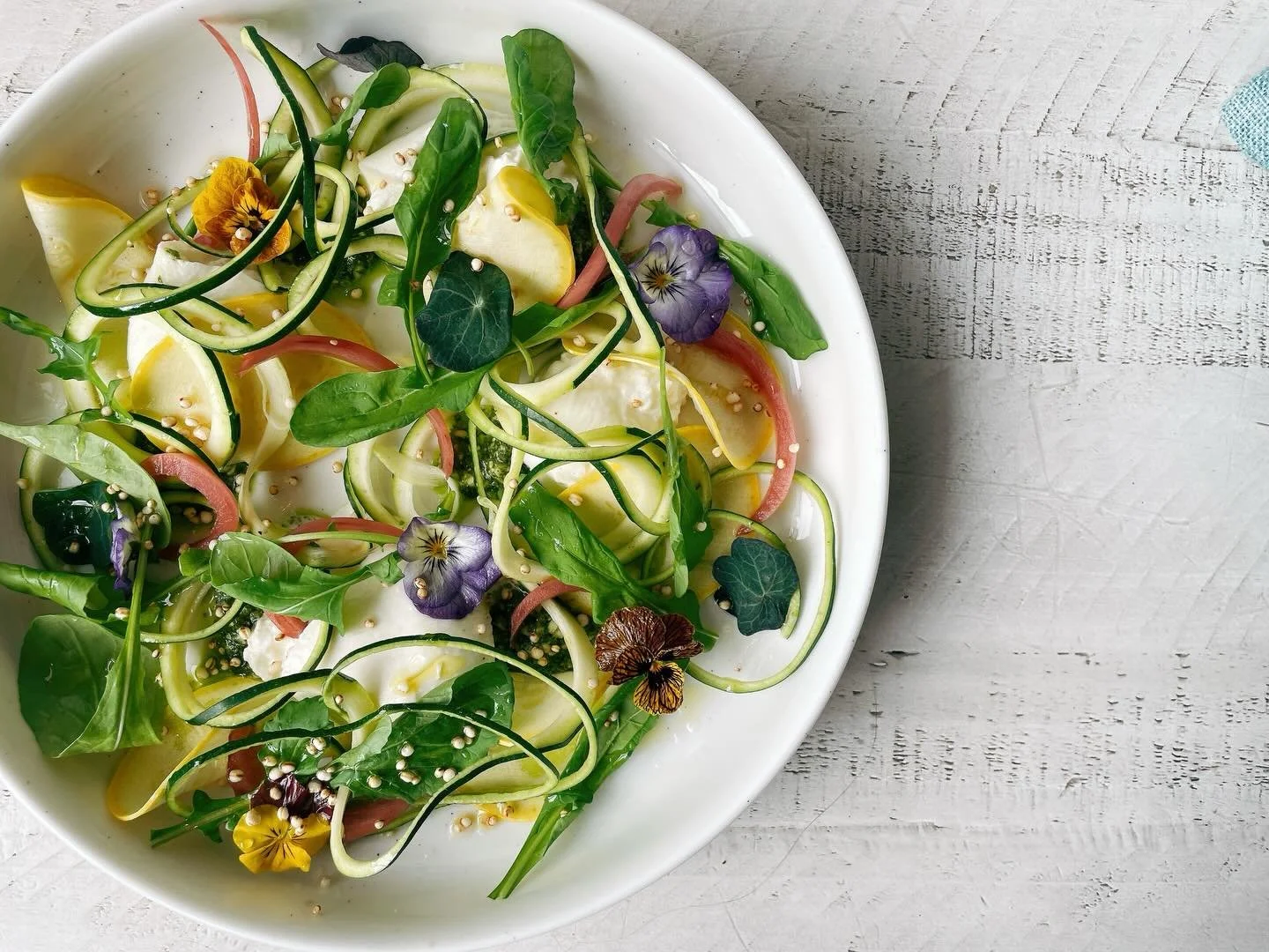 Early summer vibes are here! 🌱 
.
Try our burrata with zucchini zoodles, yellow squash, pickled red onions, basil pesto, @iola_valley_farm arugula, puffed quinoa, lemon oil, white balsamic reduction, herbs, edible pansies from @janniebirdfarm