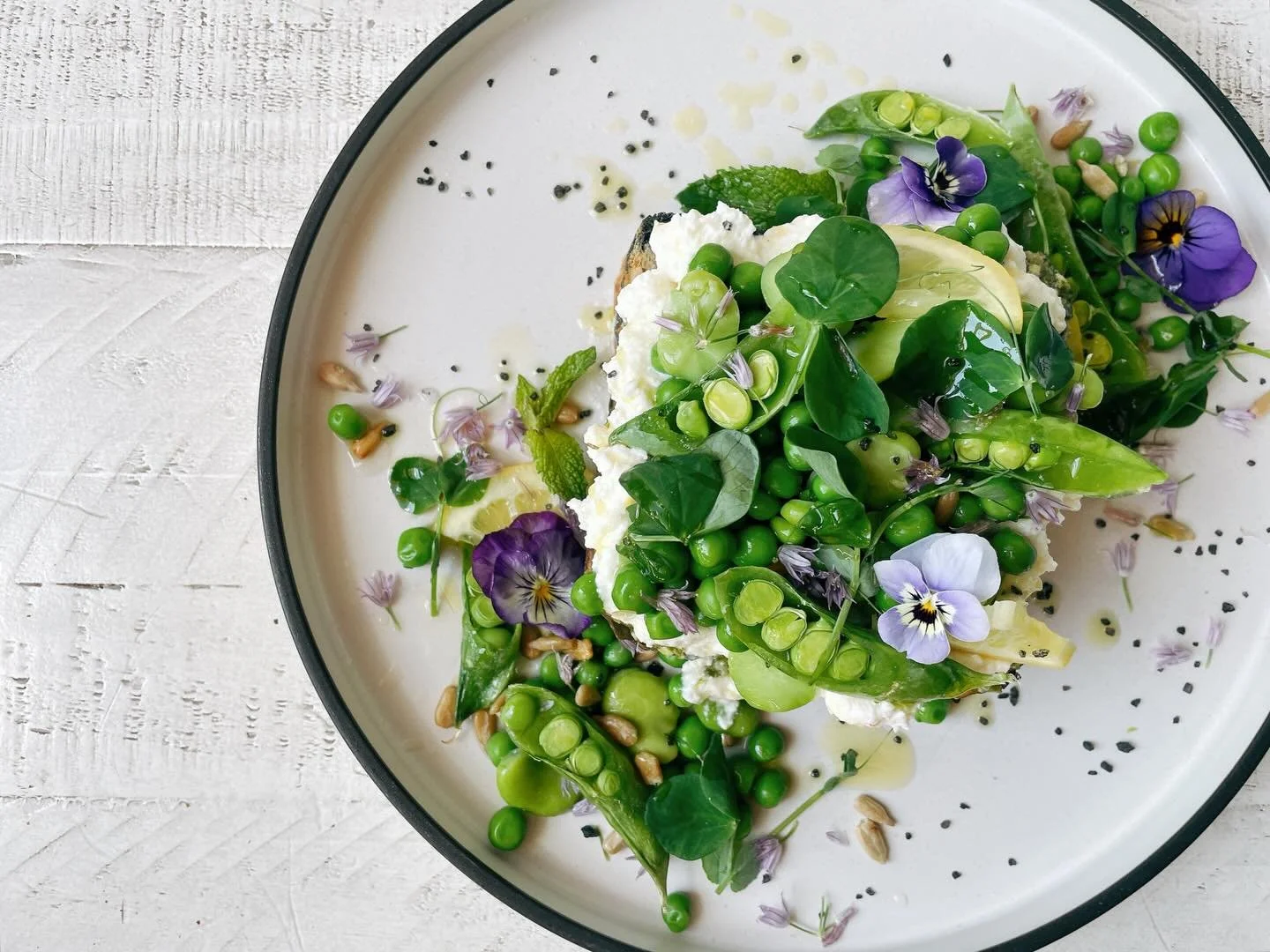 Our current fancy toast is a can&rsquo;t miss!
.
Sugar snap peas, English peas, favas, basil pesto, lemon ricotta, pickled lemons, roasted sunflower seeds, lemon oil, white balsamic reduction, Black Sea salt, pea microgreens from @grandvalley_microfa