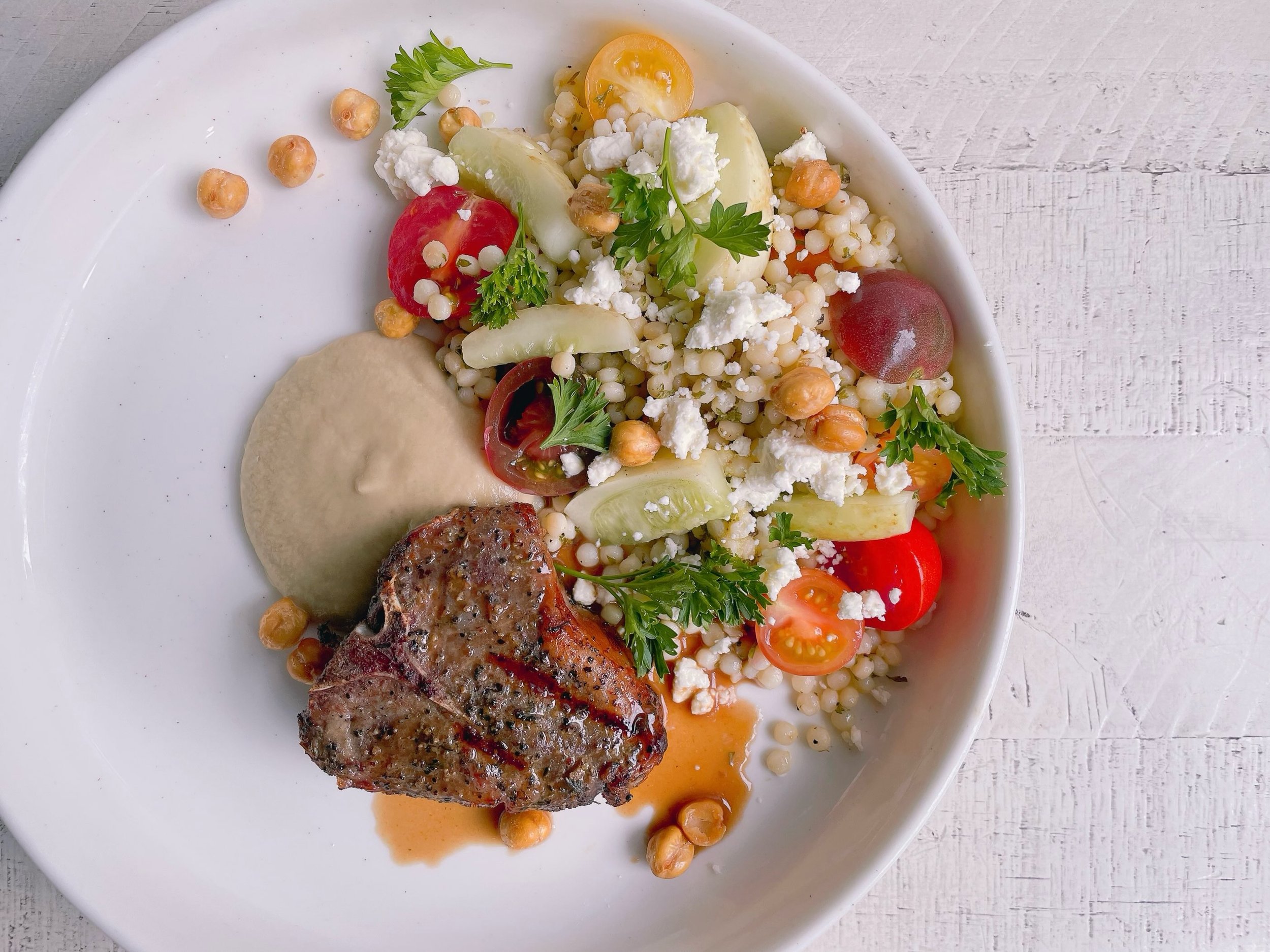Lamb loin chop with red wine au jus, eggplant puree, Mediterranean couscous salad with tomatoes, lemon cucumbers, feta, parsley, tossed in a lemon shallot citronette with crispy chickpeas and parsley.
.
We&rsquo;re open Wednesday through Monday! Come