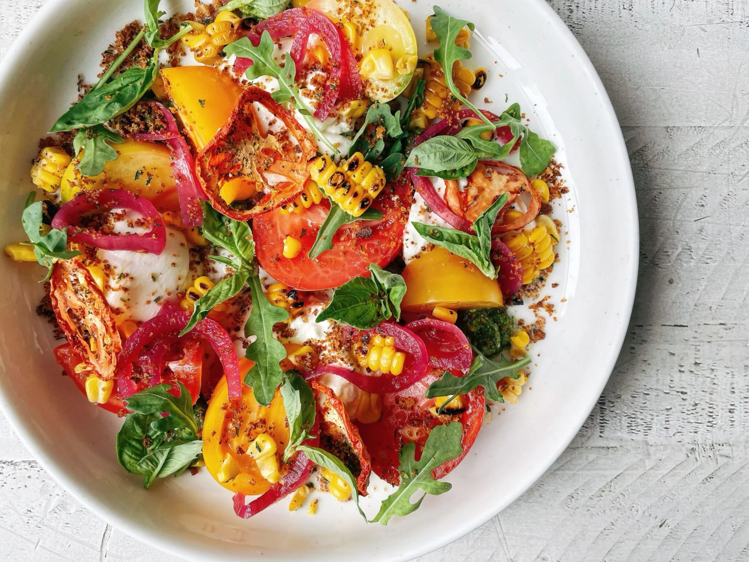 The fall burrata salad has all the things going! 
.
With heirloom tomatoes, roasted corn, pickled red onion, arugula, basil, basil pesto, breadcrumbs, roasted tomato oil, white balsamic reduction 🍅 🌽 🌱 
.
We&rsquo;re open every night except Tuesda