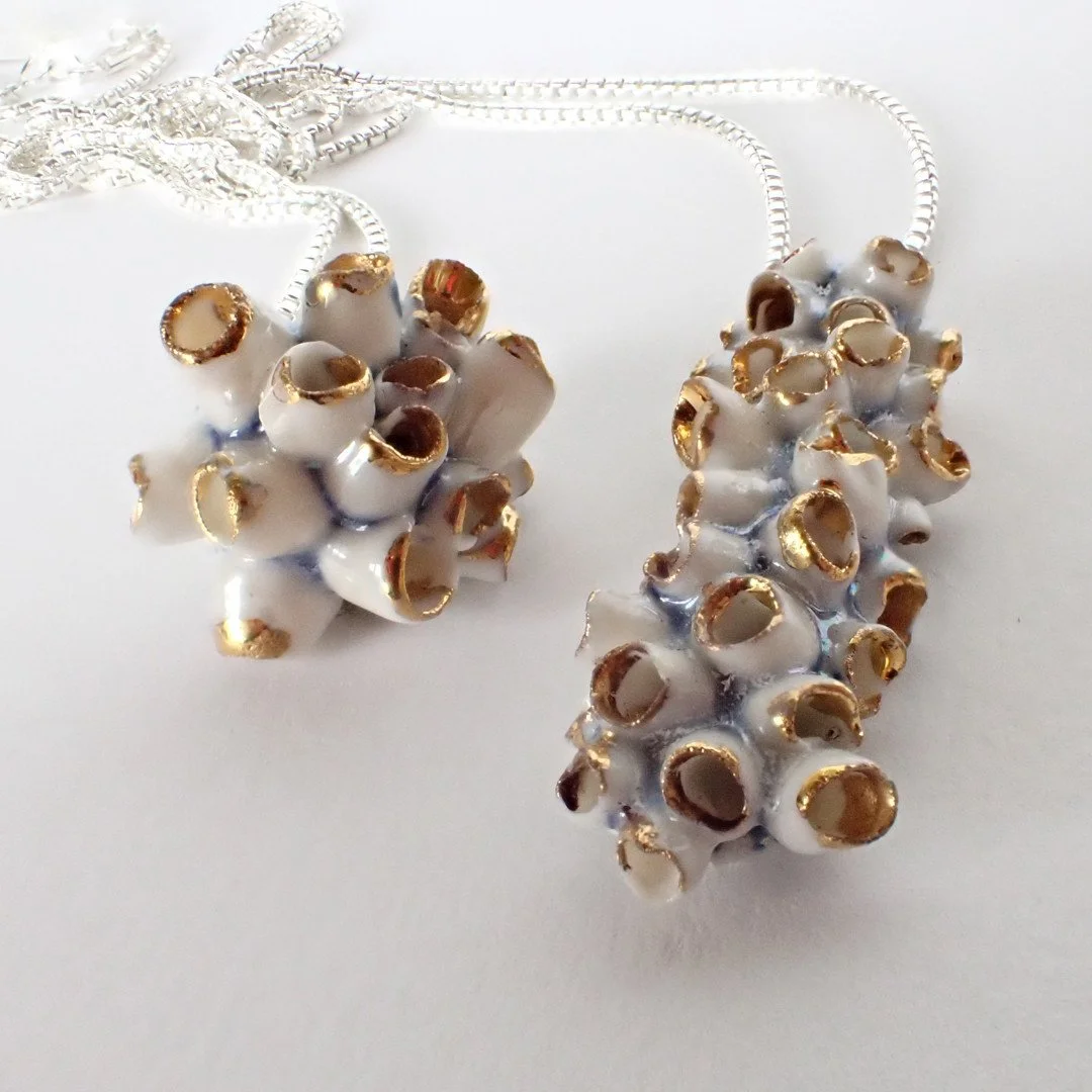 More tiny porcelain coastal designs, this time two small pendants mounted on a sterling silver back.  The cobalt blue slip peeks through the glaze and gold lustre edges the tips of the barnacle forms, each a one off design. ⁠
Available to purchase at