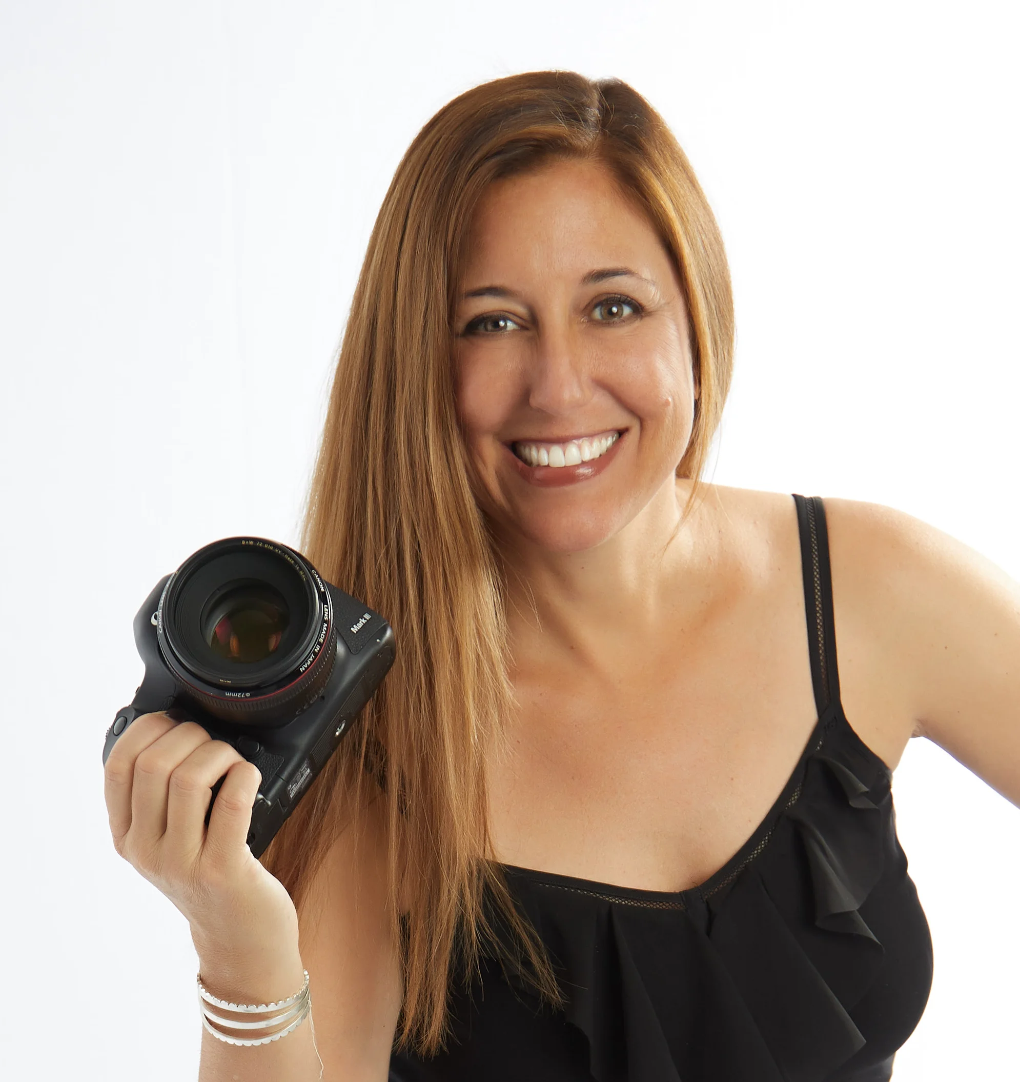 Missy Goldwyn, Boudoir Photographer in the San Francisco Bay Area, is smiling and holding a camera.