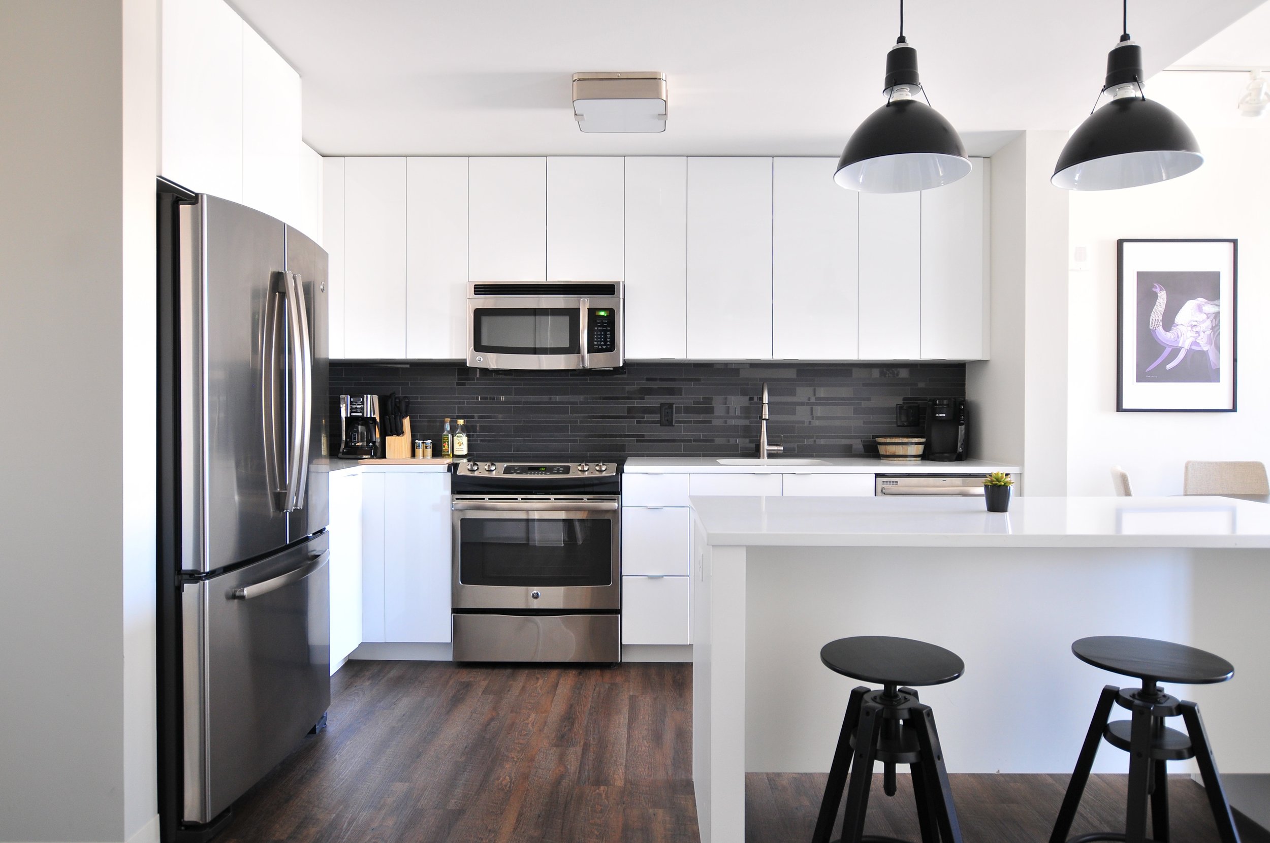  Modern black and white kitchen with breakfast bar and black bar stool.  