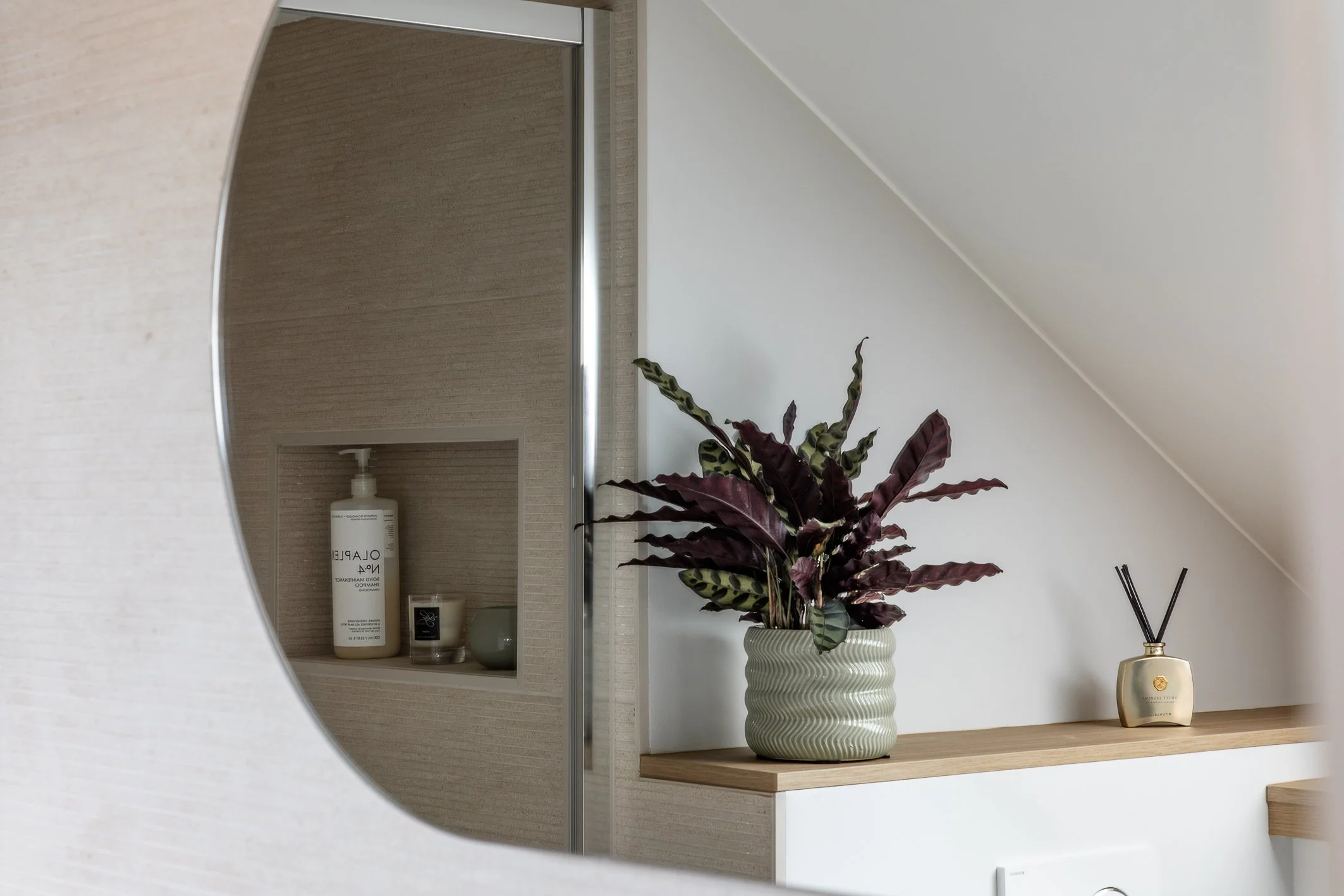 photographie d'un reflet de miroir de salle de bain détaillant une niche en carrelage dans un mur de la douche. Photographie d'architecture intérieure prise en lumière naturelle à Bruxelles