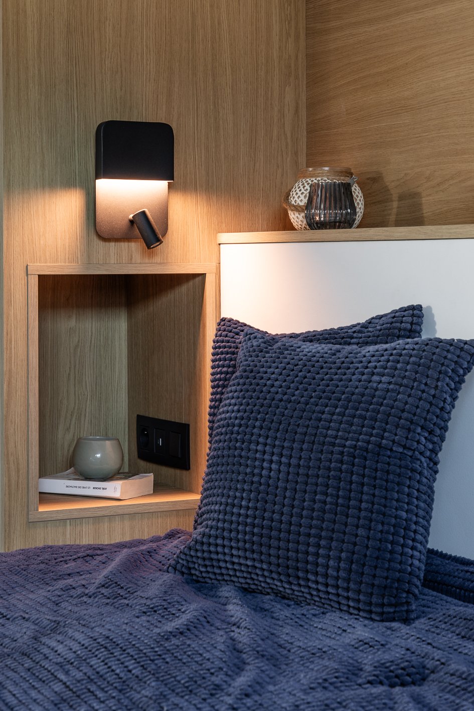 Photographie de détail d'une tête de lit avec liseuse et table de nuit intégrée prise en lumière naturelle - architecture d'intérieure par Stéphanie Asta