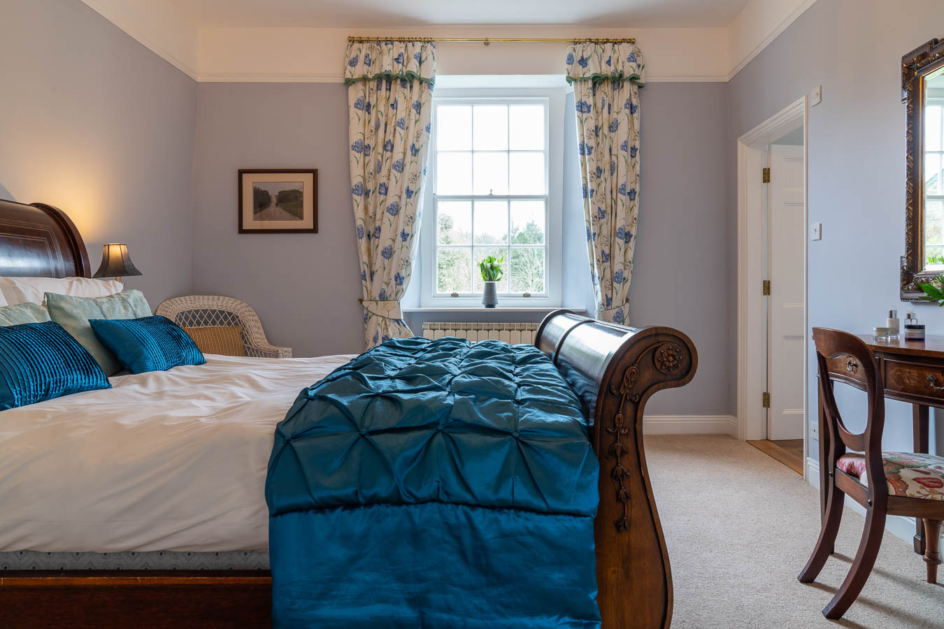 The Blue bedroom in Flear House with king size sleigh bed with matching dresser and bedsides and large sash window overlooking the front garden.
