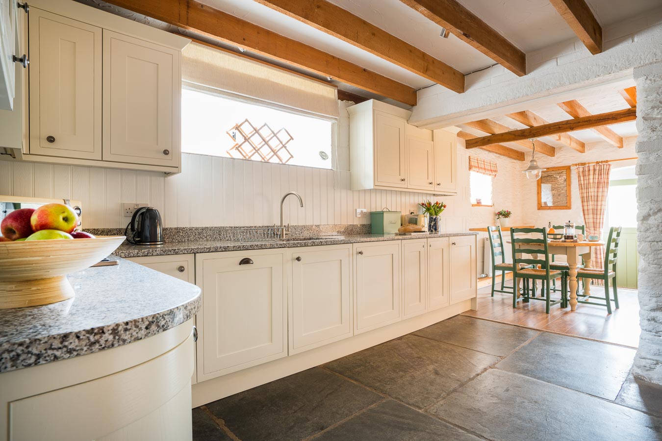 The stylish cream kitchen with granite worktops and slate floor Quarry cottage Flear Farm.