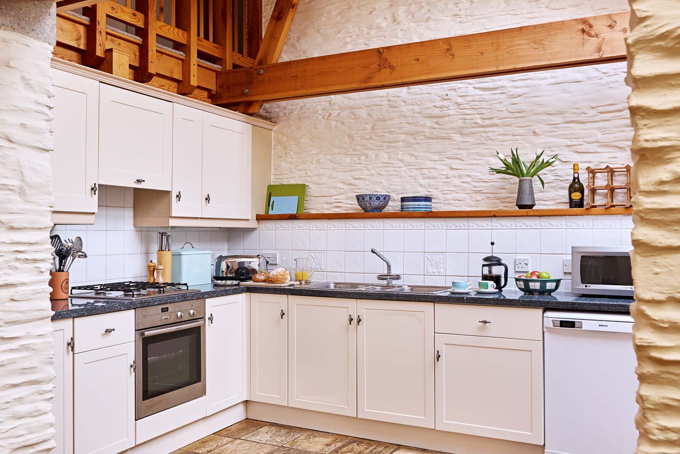 The shaker style kitchen in the Linhay cottage with black granite work tops and heated tiled floor at Flear Farm. 