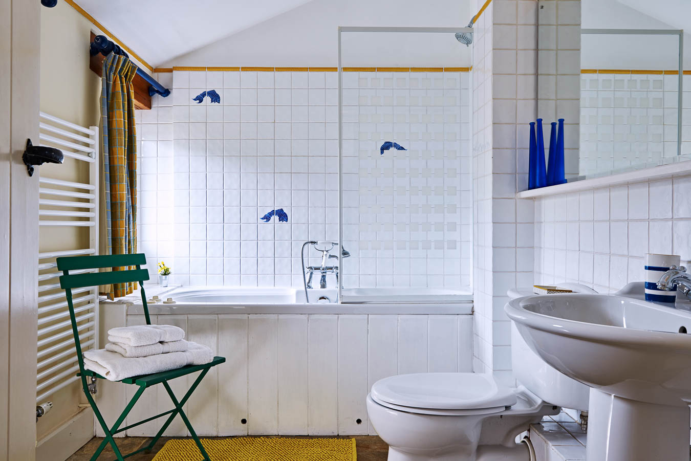 The Linhay cottage Flear Farm master bedroom en suite with chrome bath accessories and blue and yellow theme. 