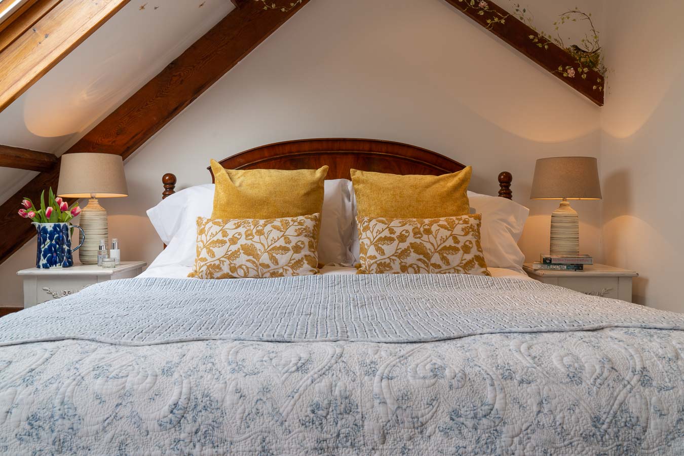 The gorgeous master bedroom, with mahogany bedhead and sumptuous bedding and cushions. Mangers cottage Flear Farm Devon. 