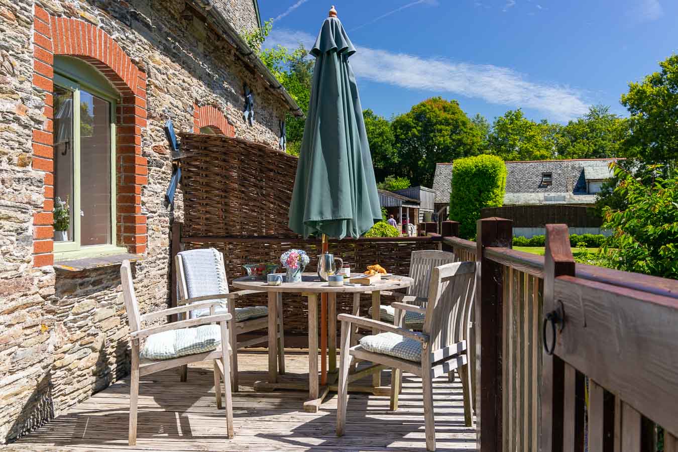 The private south facing sun terrace of Mangers cottage Flear Farm. Outdoor furniture and green views of Devon countryside. 